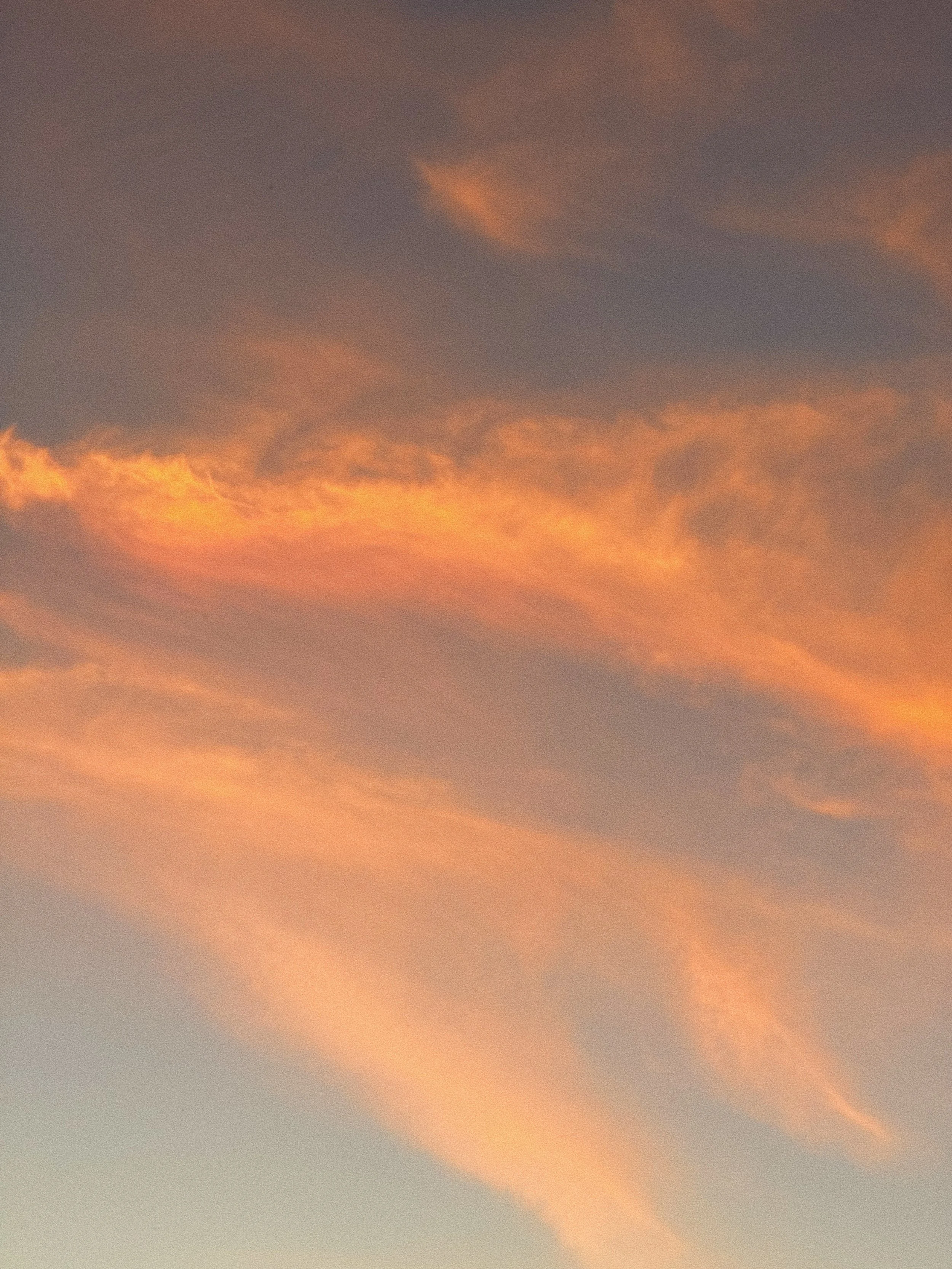 A sky at sunset with orange and purple clouds.
