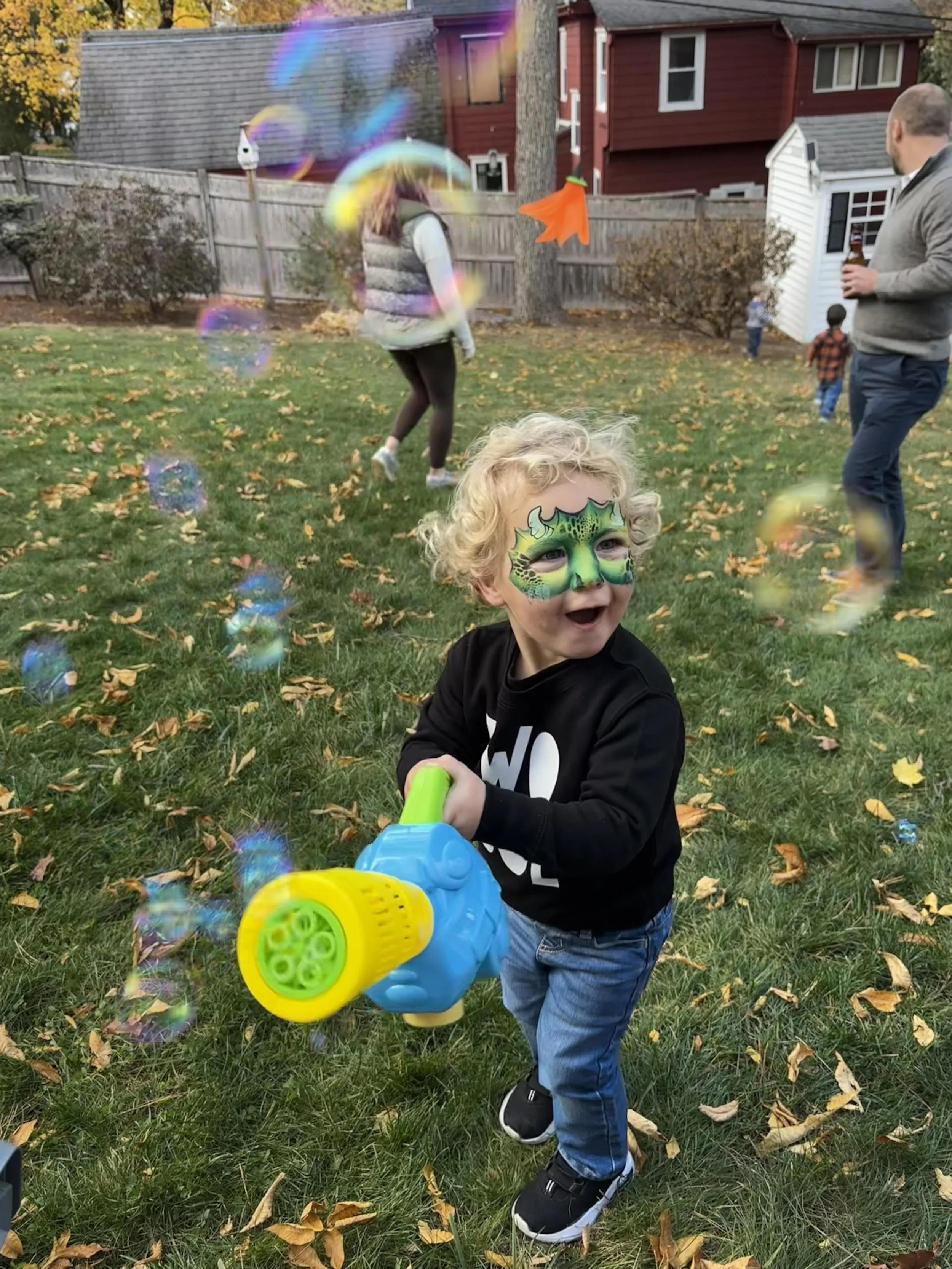 Child with colorful dinosaur face paint at a Boston birthday party