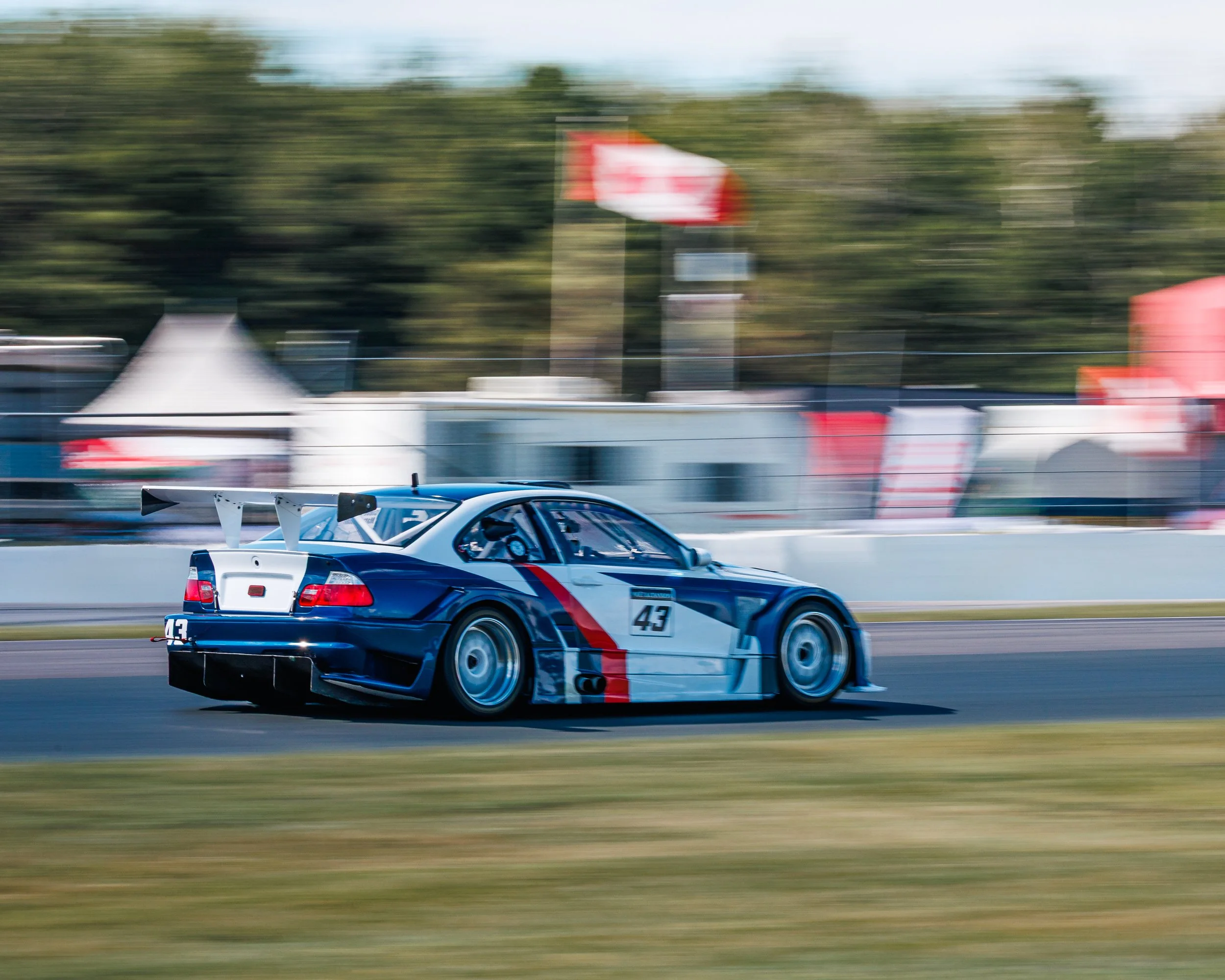 Race car on a race track with blurred background, showcasing motion and speed.