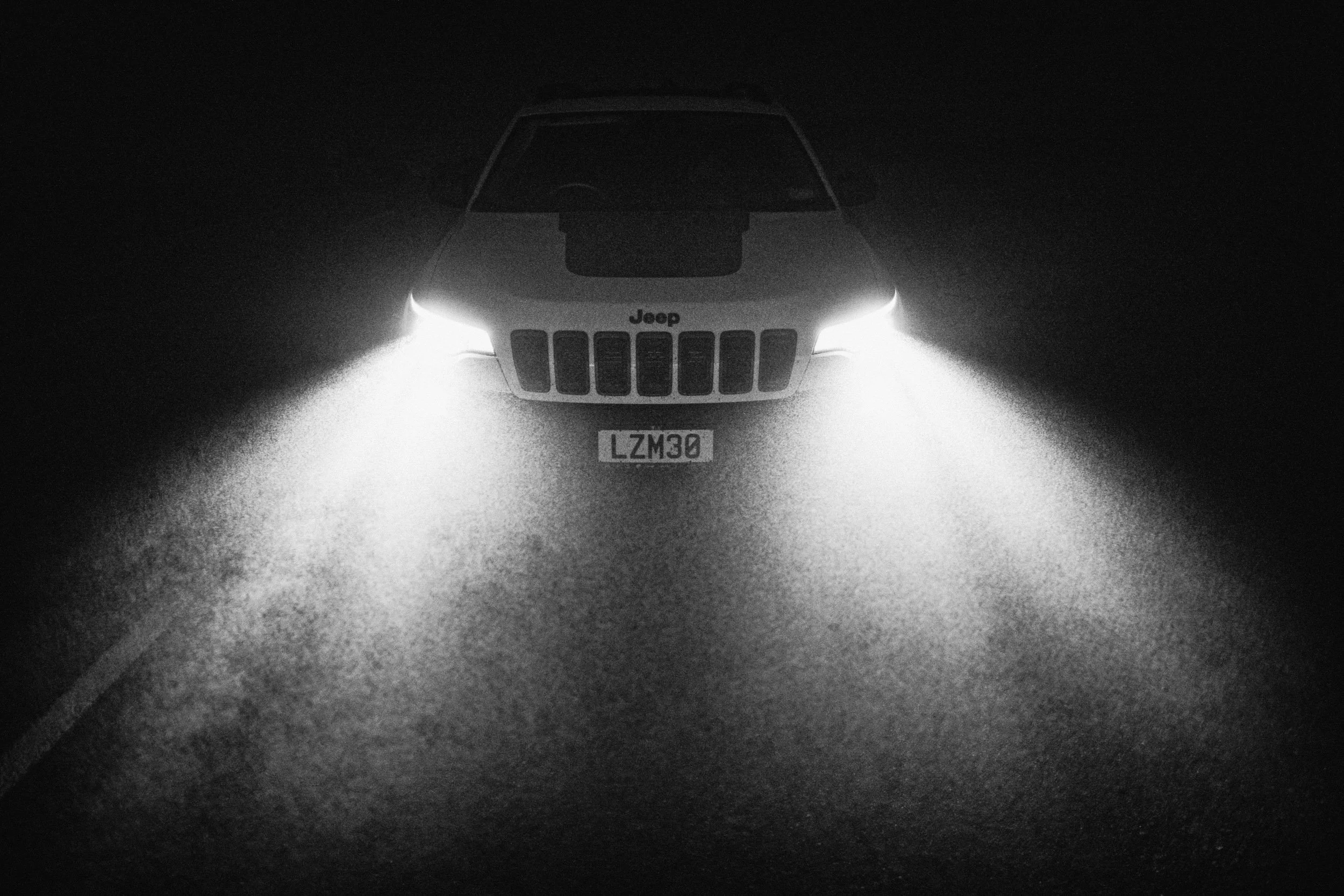 Car with headlights on, dark background