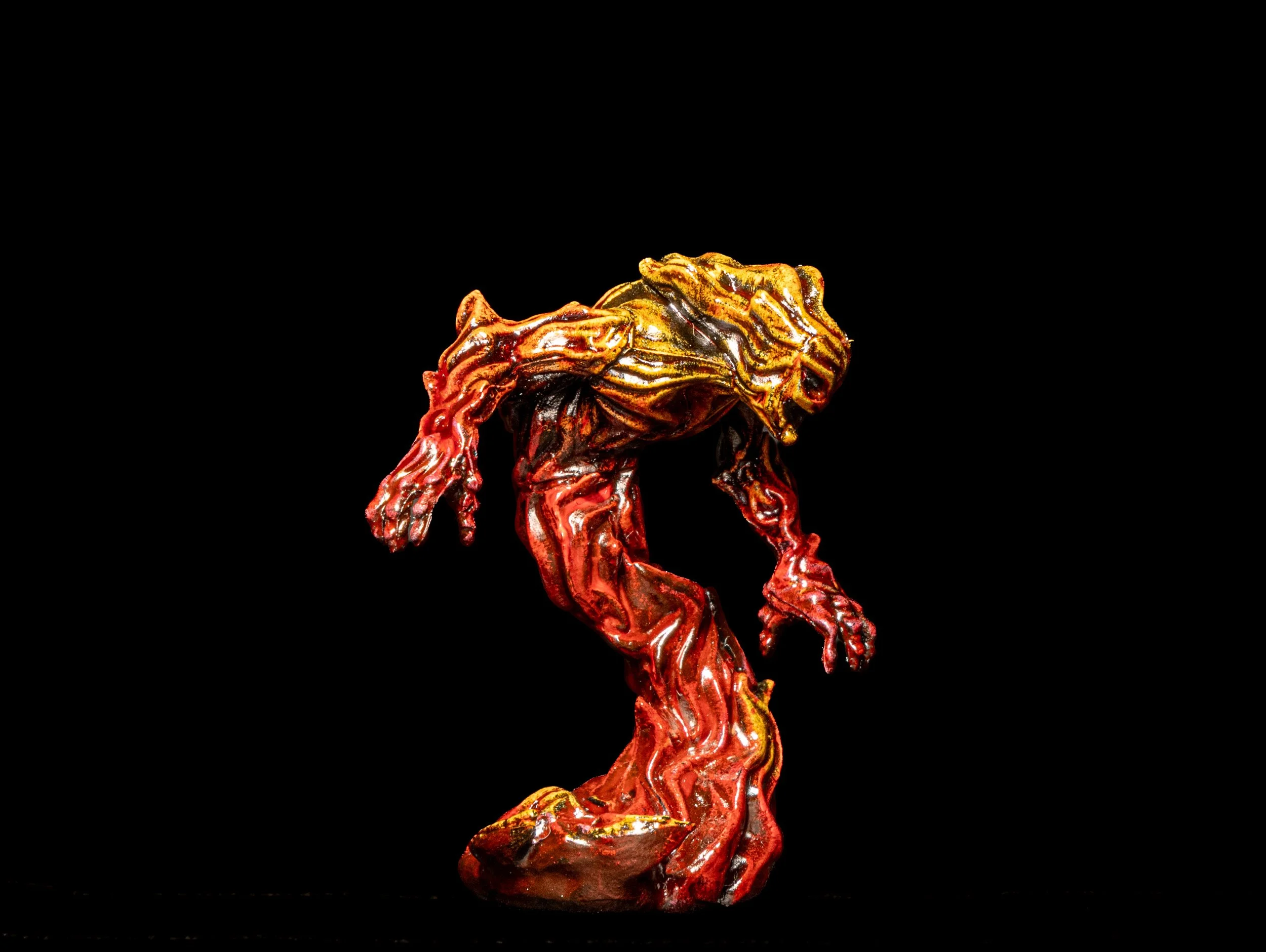 A glass sculpture of a dog with a mix of red, orange, yellow, and black colors, displayed against a black background, with a highly reflective surface.
