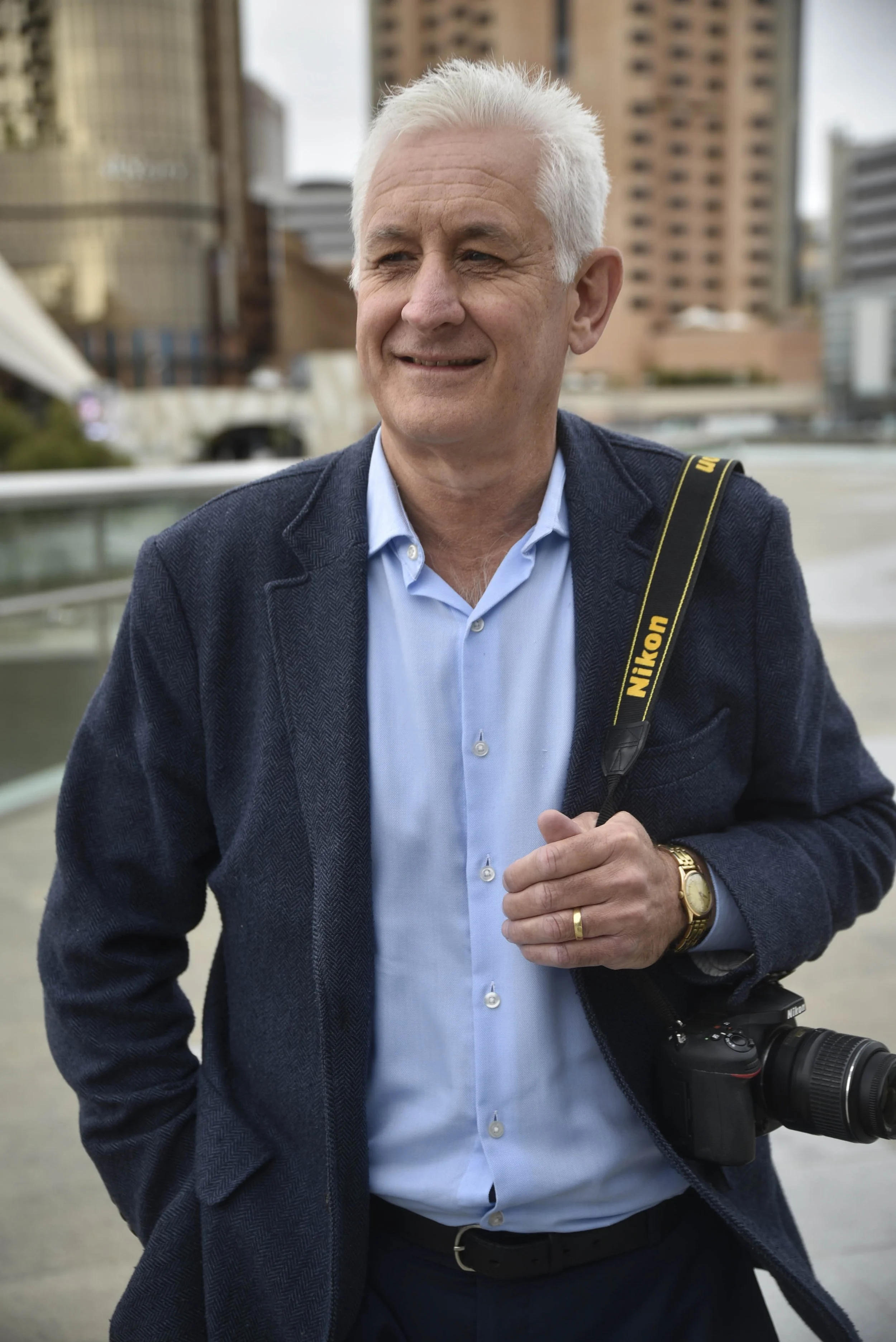 Headshot of smiling male wearing a camera over his shoulder