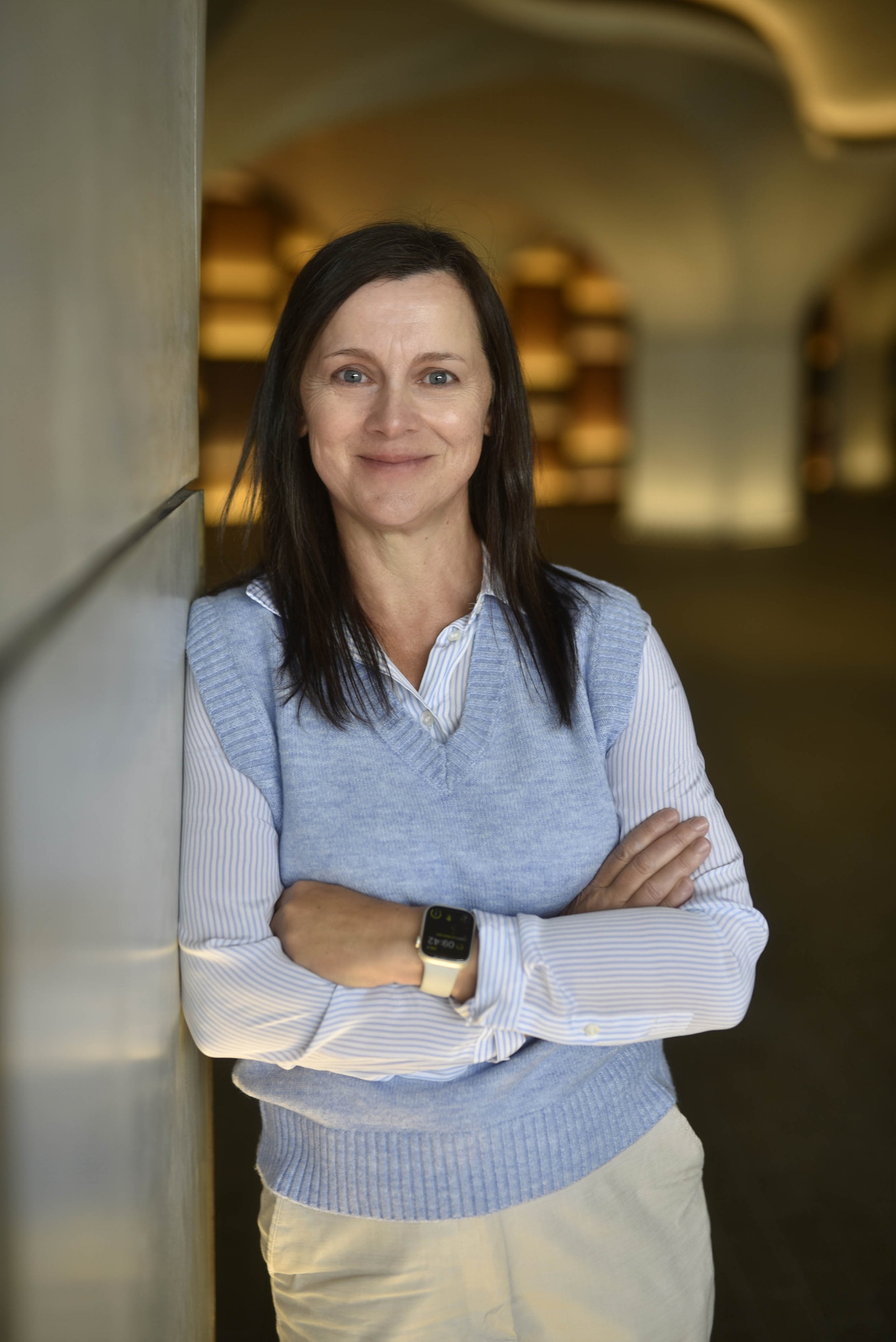 Headshot of smiling female tutor with long braids wearing a lanyard.