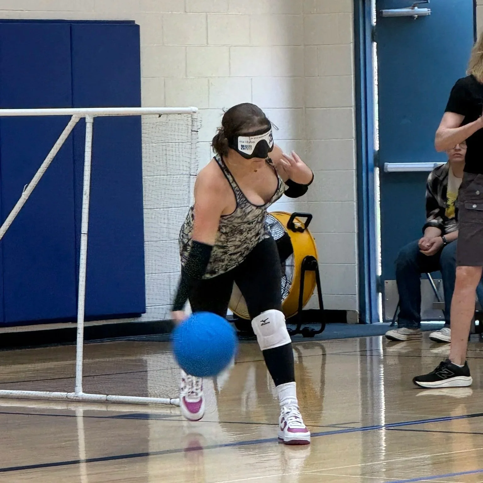 Anna throwing a goalball during a Goalball practice game.