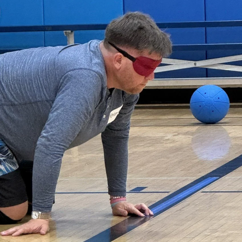 Brendan in his defensive Goalball ready position wearing a red eyeshade.