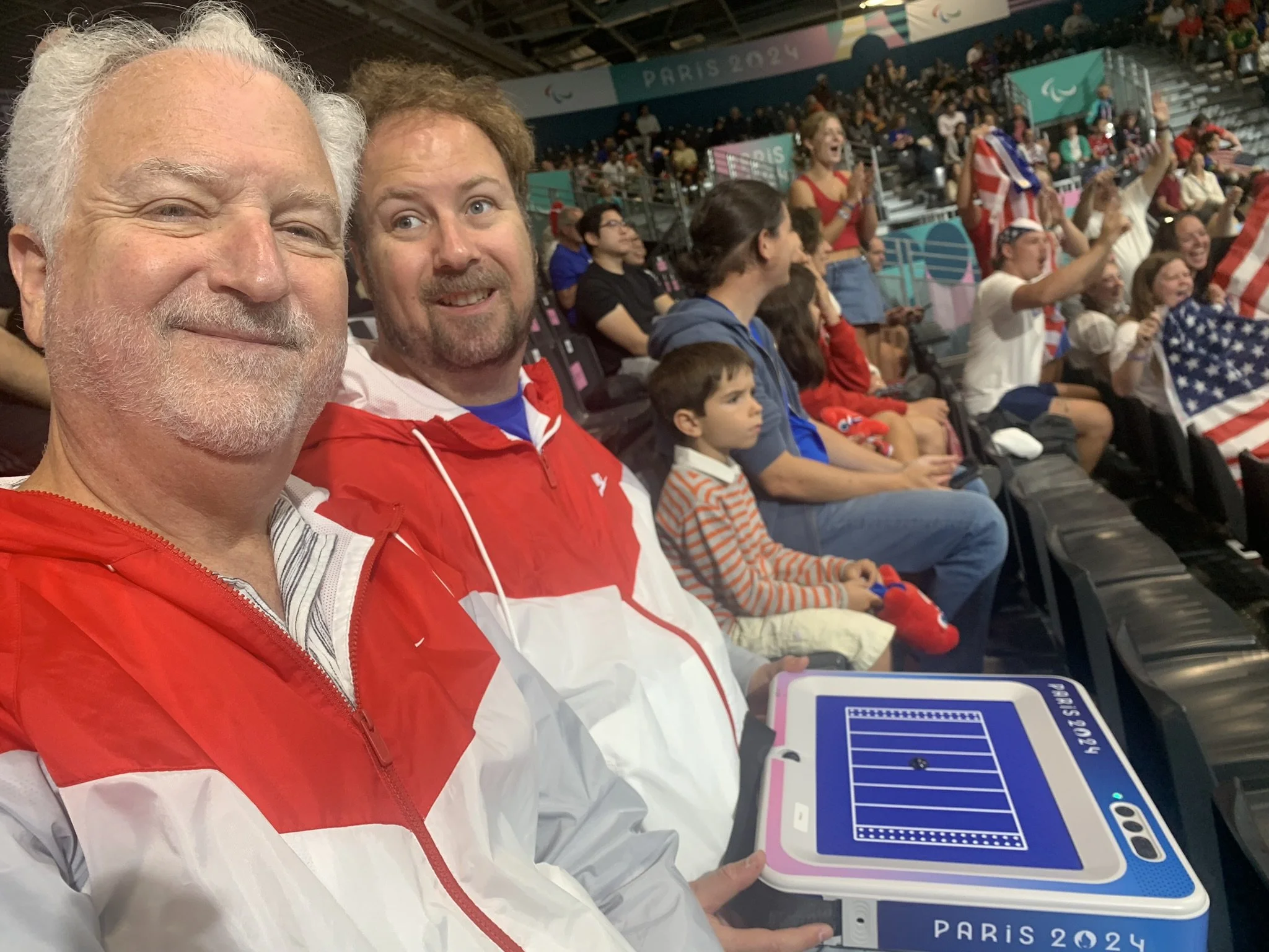 A picture of Neal and Mike Meyers sitting in the stands watching the goalball competition at the 2024 Paris Paralympics.