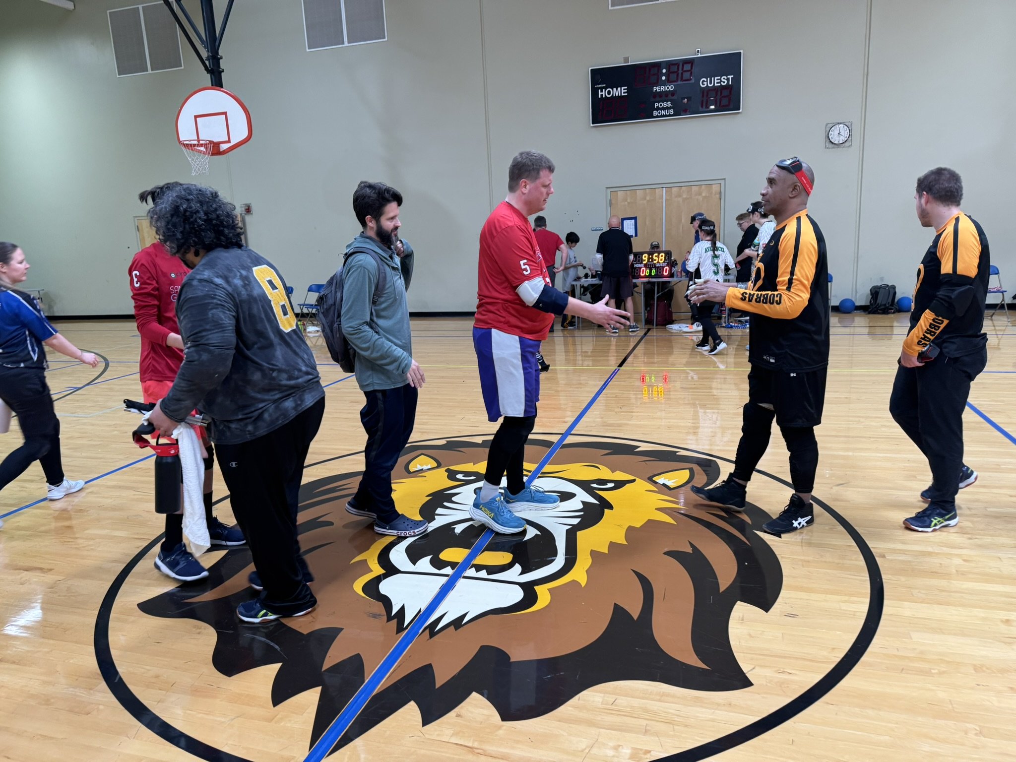 Photo of Joe Hamilton, Coach Boyle and other players, shaking the hands of the opposing team after a game at the 2026 Cascade Goalball tournament in Portland, Oregon.