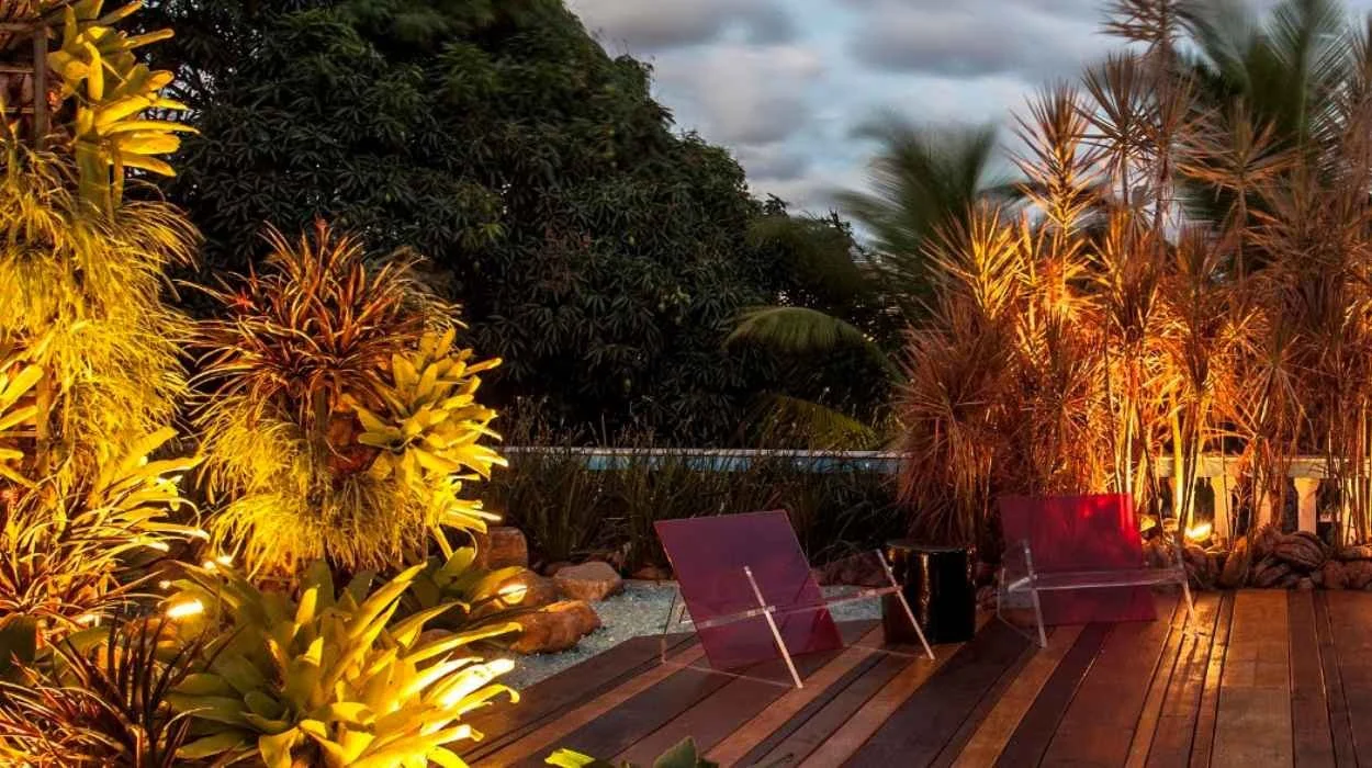 Jardim do Solar, ambiente de Marcos Malamut e Fernando Rocha para a CASACOR Bahia 2014, com vegetação tropical, iluminação cênica, deck de madeira e cadeiras de desenho autoral.
