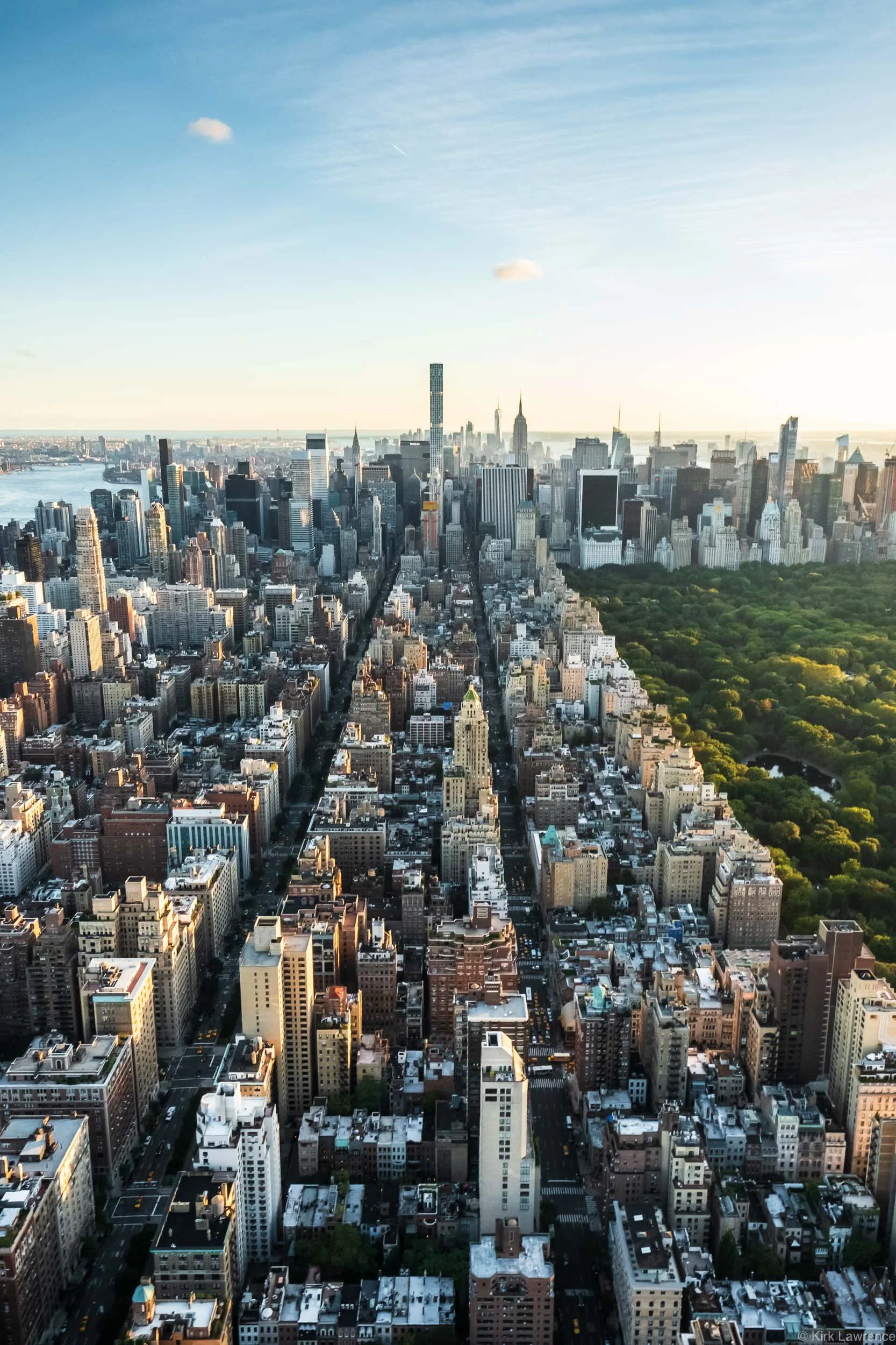 Aerial view of New York City skyline during daytime, showing numerous tall skyscrapers and tall buildings with Central Park visible in the lower right corner.