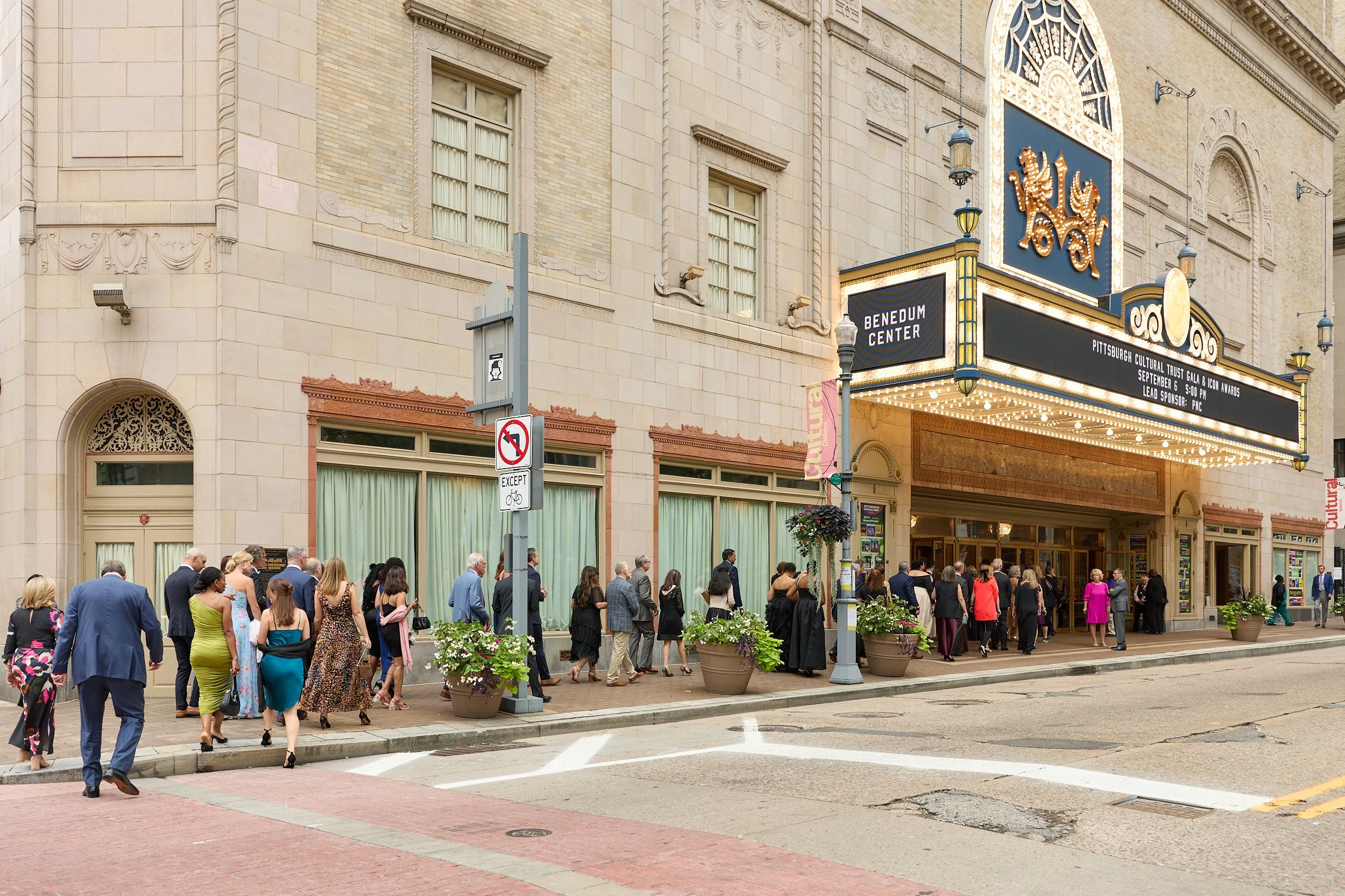 People dressed in formal attire gathering outside a theater with a marquee that reads "Pittsburgh Cultural Trust Gala & Icon Awards, September 6, 5:00 PM" at the Benedum Center.