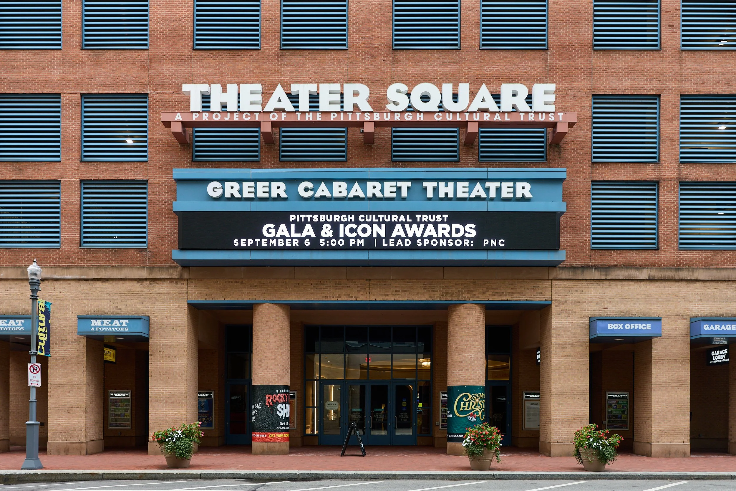 The exterior of the Greer Cabaret Theater at Theater Square, with signs for the Pittsburgh Cultural Trust Gala and Icon Awards event, and potted flowers outside.