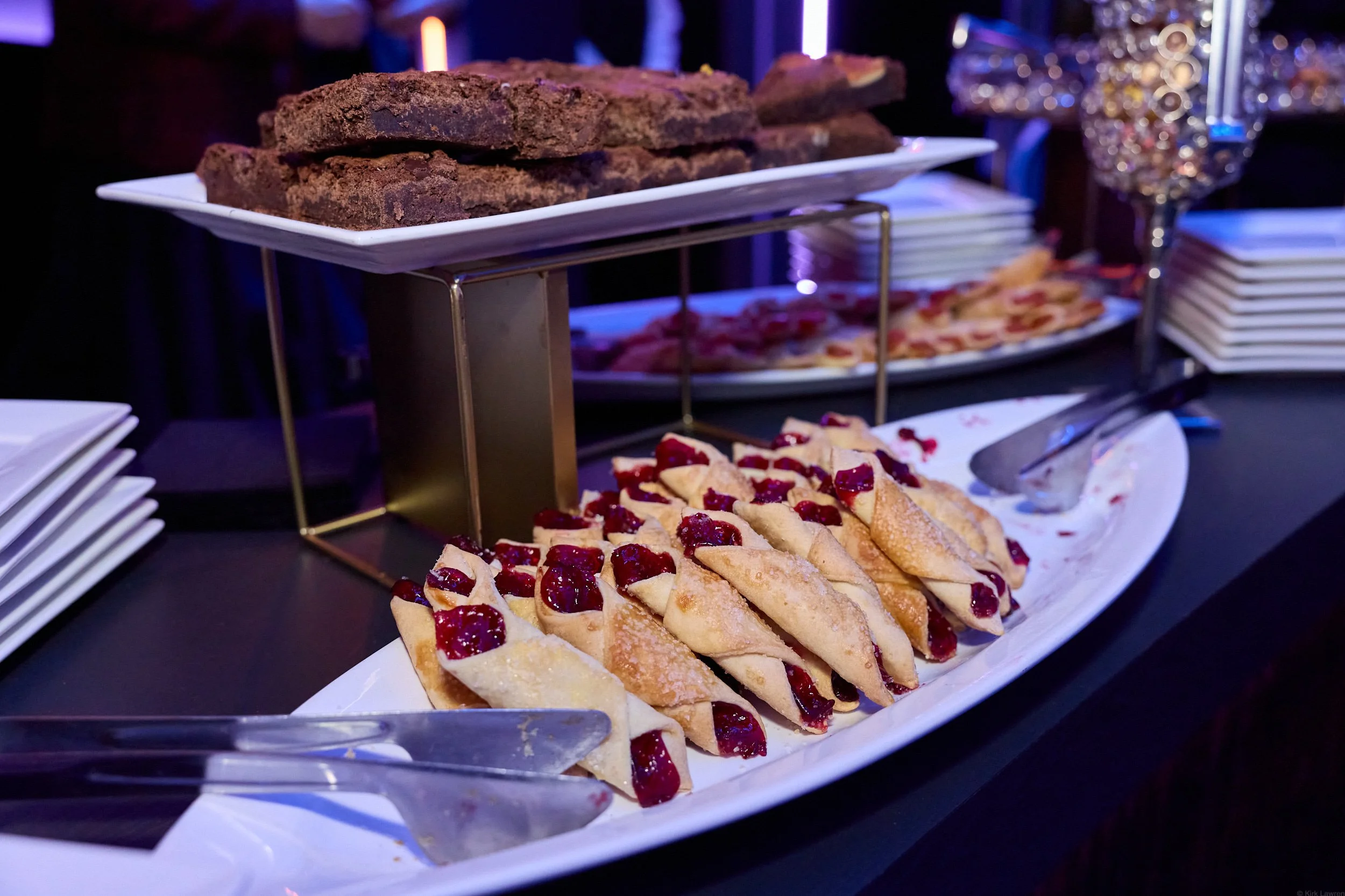 Tray of sliced cherry-filled pastries on a white platter at a buffet table.