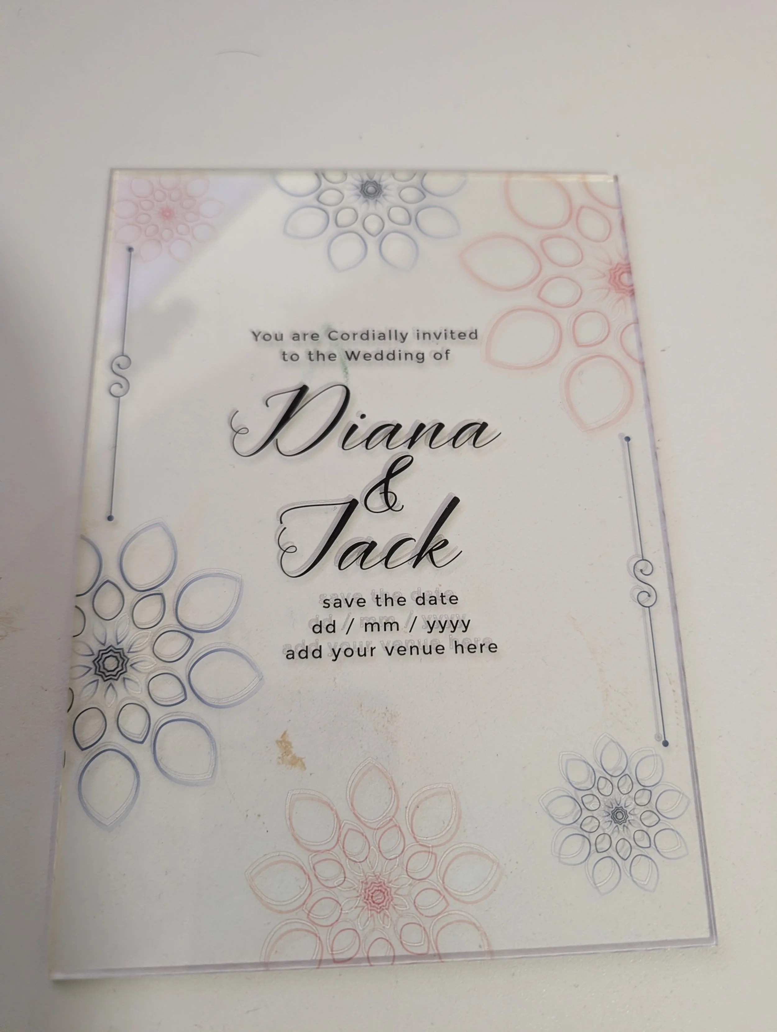Wedding invitation with floral designs and space to fill in wedding details, including names, date, and venue.