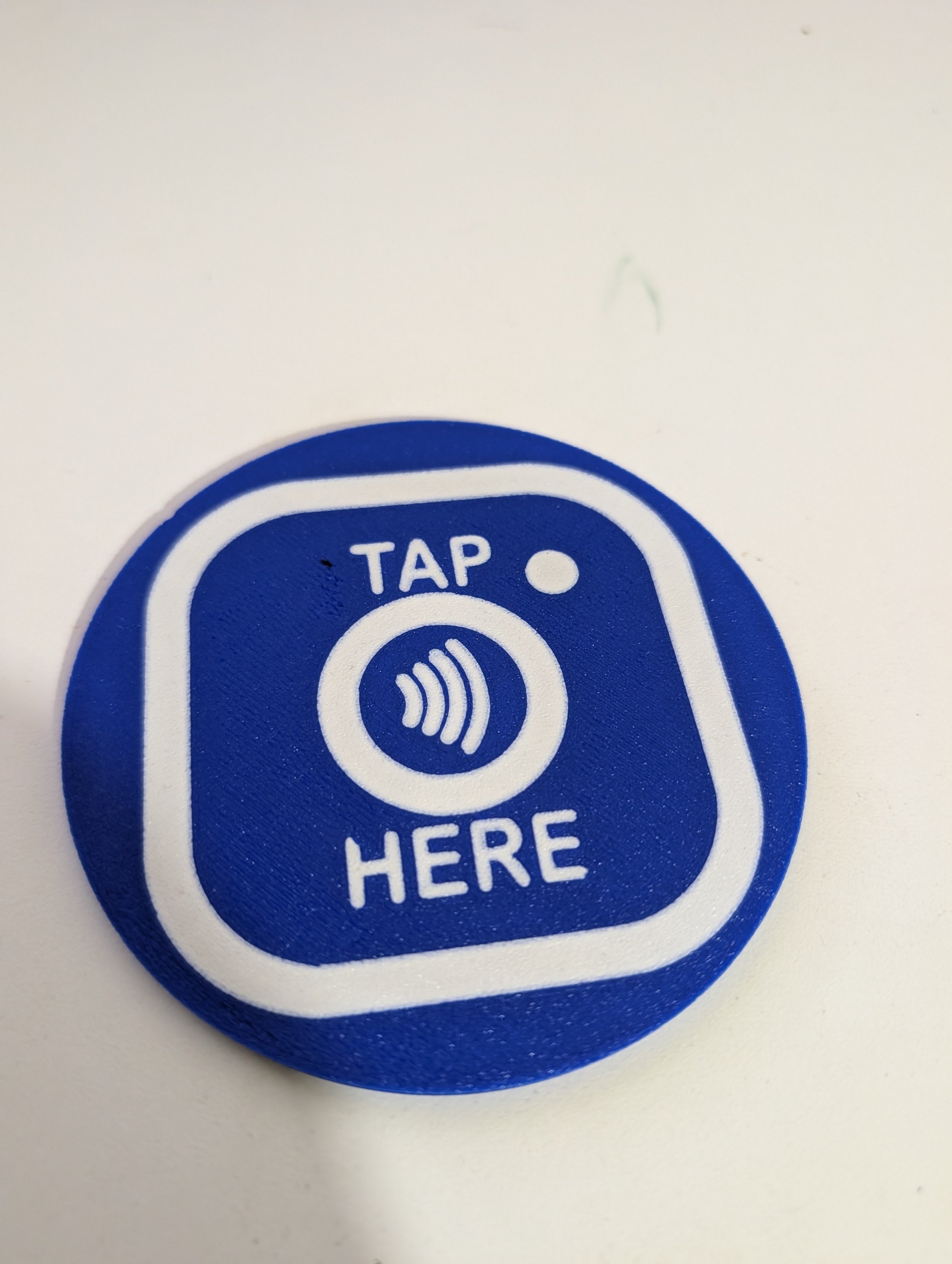 Blue circular sticker with a white contactless payment symbol and the words 'TAP HERE' on a white background.
