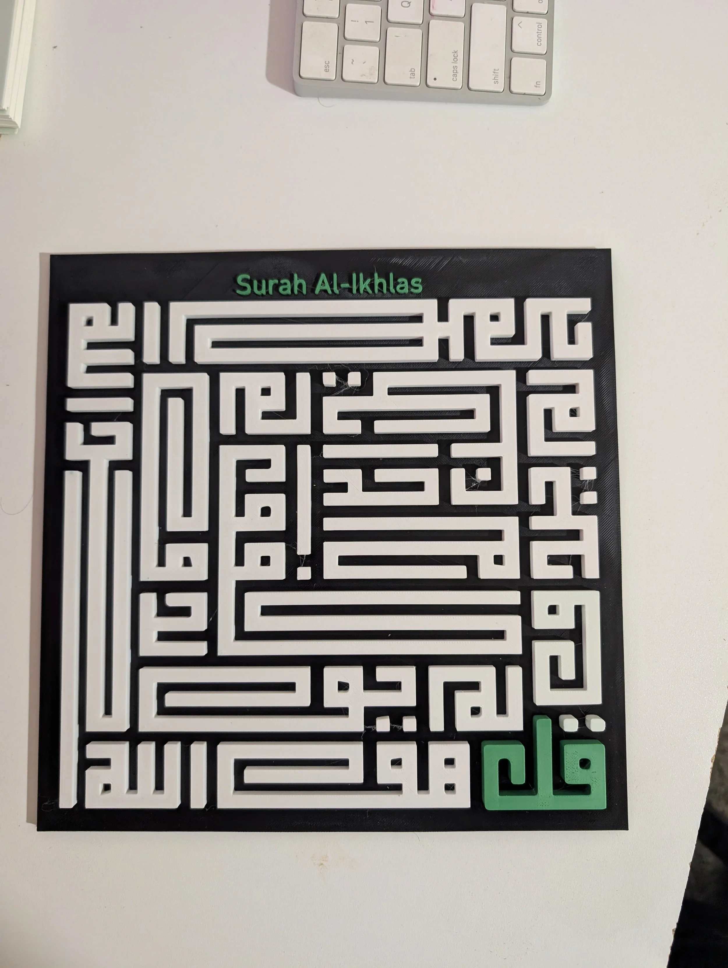 A black maze with white pathways, featuring green text that reads 'Surah Al-Ikhlas' at the top, and green buttons at the bottom right corner.