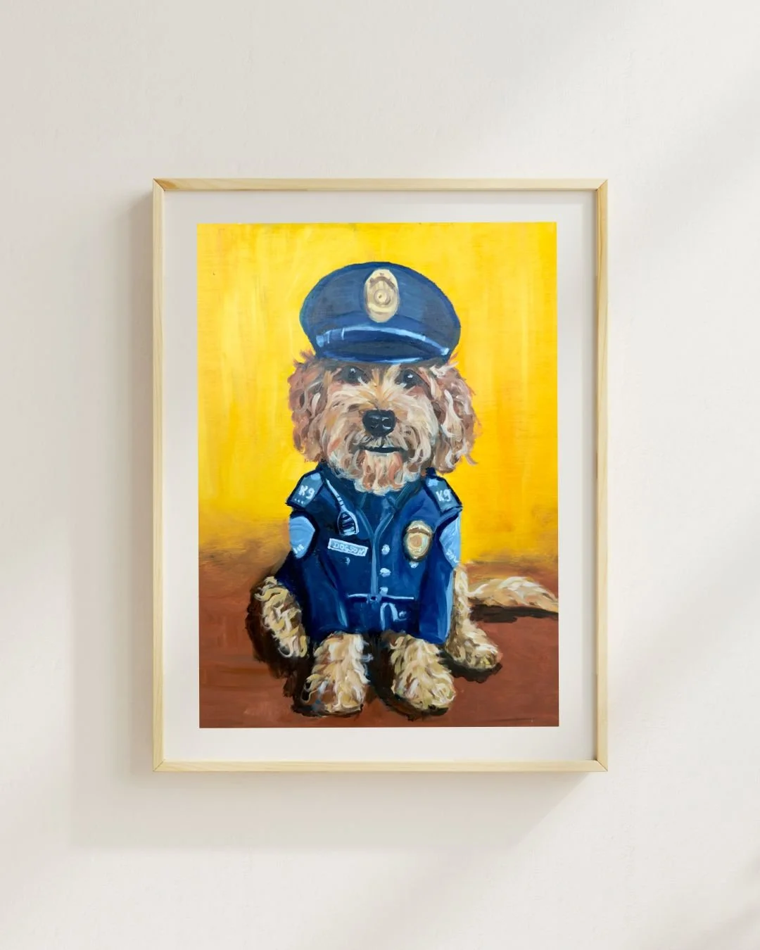 Original oil painting of a fluffy golden dog sitting and dressed as a police officer against a bright yellow and orange background. The
