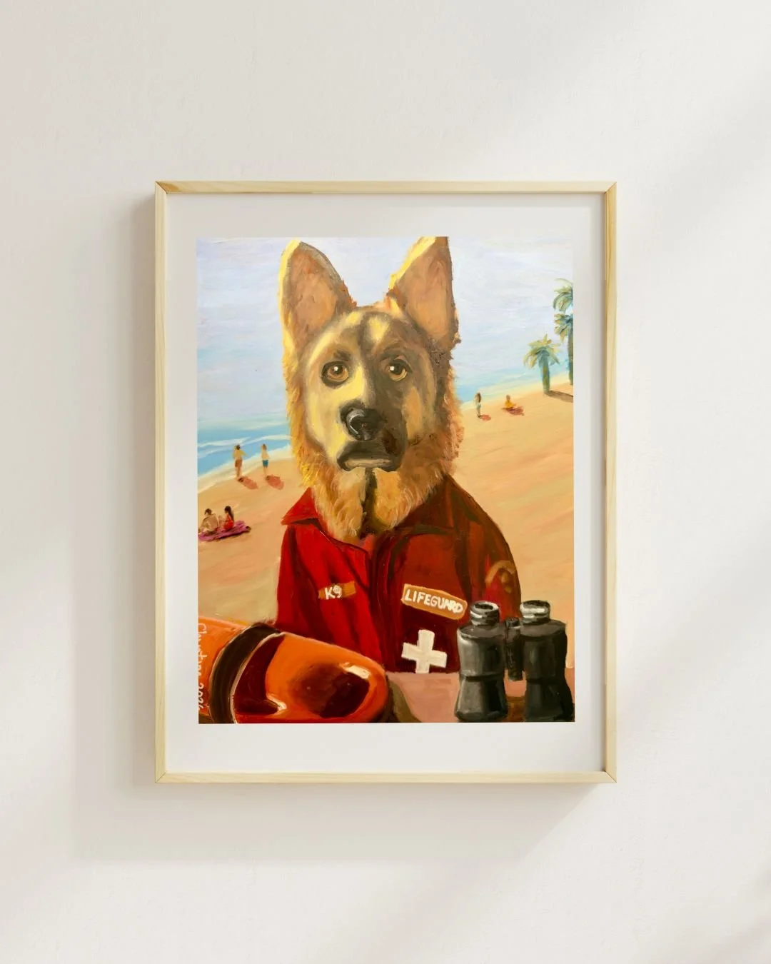 Original oil painting or prints of a German Shepherd dog dressed as a lifeguard on a sunny beach. The dog is wearing a red jacket with K9 and Lifeguard patches and a white cross.