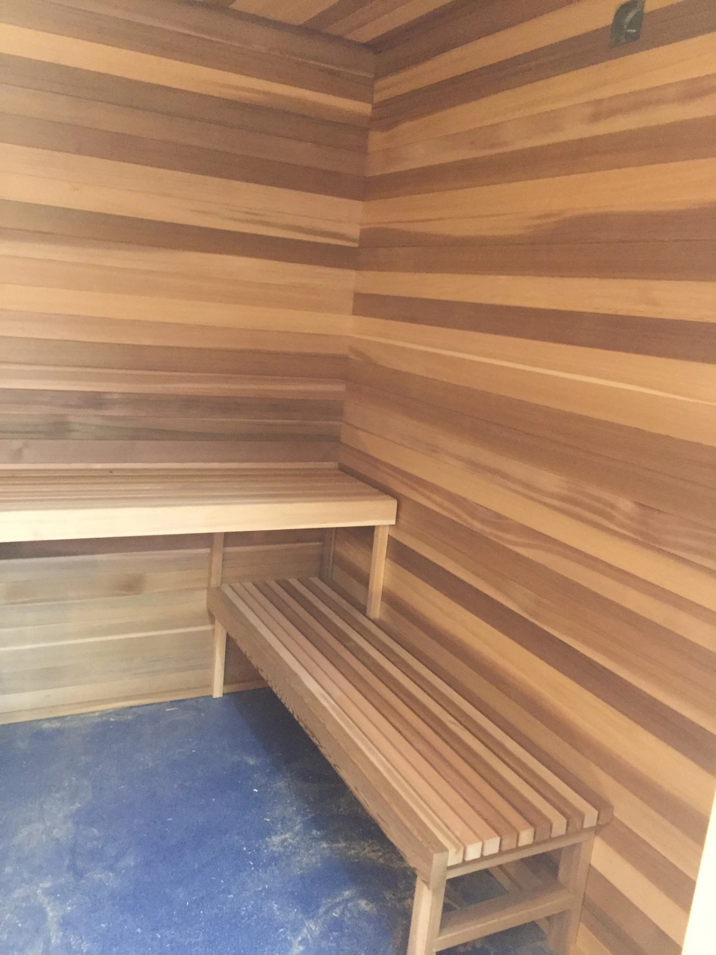 Wooden interior of a sauna with benches along the walls.