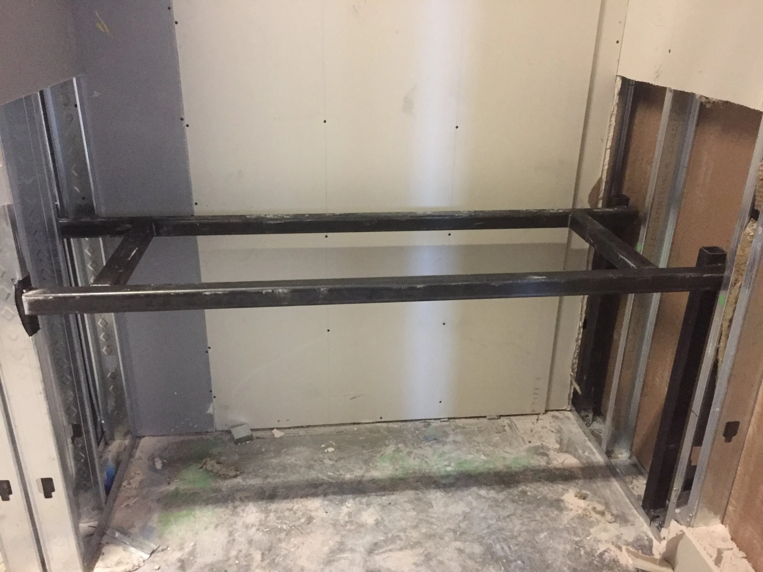 An unfinished wall with metal framing and drywall, possibly in a construction or renovation project.