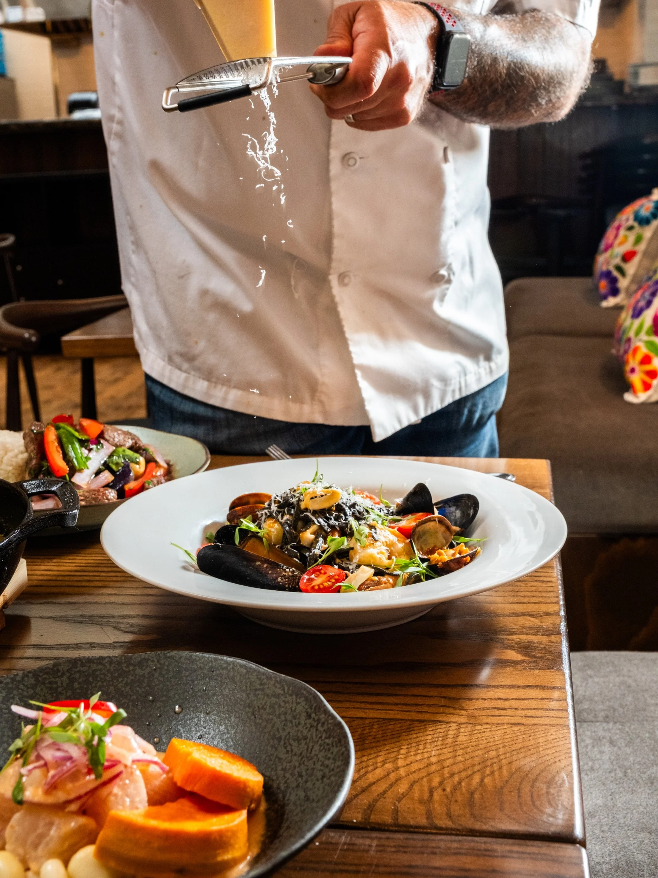 The moment the Manchego hits the Fideos Achupados 🤌😍

If you&rsquo;re a fan of seafood pasta, this one&rsquo;s for you: squid ink linguini, seafood and shellfish bisque, aj&iacute; panca cream, tomato, Manchego cheese 🍝 

Book your reservation and