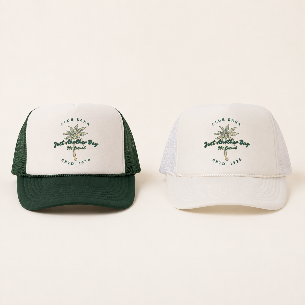 Two baseball caps, one green with white front panel and one all white, both featuring a palm tree and text that reads 'Club Sara, Just Another Day, Yes Casual, ESTD. 1976' on the front.
