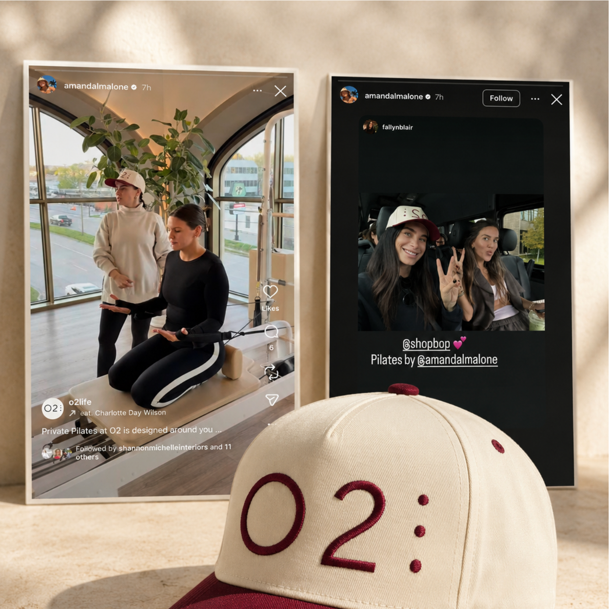 Two Instagram-style photos of women, one in a Pilates studio and the other on a bus, both wearing baseball hats and making peace signs. A beige and maroon baseball cap with '02:' embroidered on it is in the foreground.