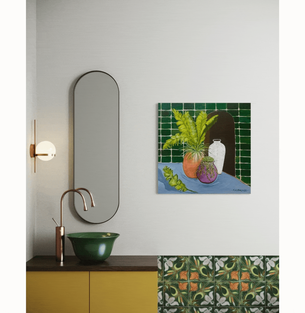Interior bathroom wall with oval mirror, wall-mounted light fixture, green vessel sink, a yellow cabinet, a colorful still life painting of vases and plants, decorative tiles with floral pattern.