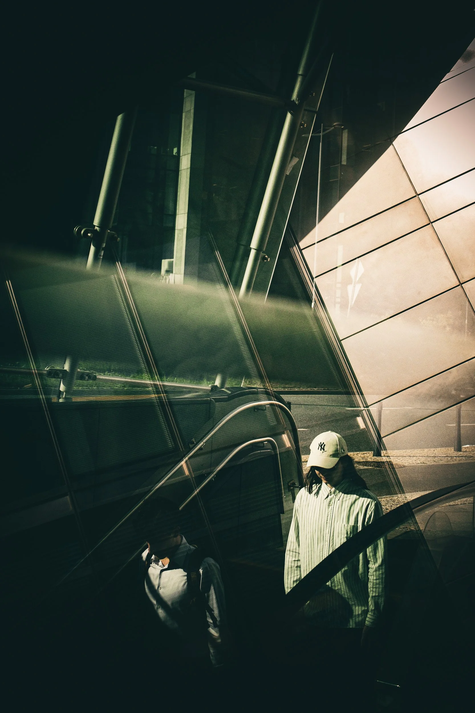 Reflections of people and modern architecture layered across a glass façade.