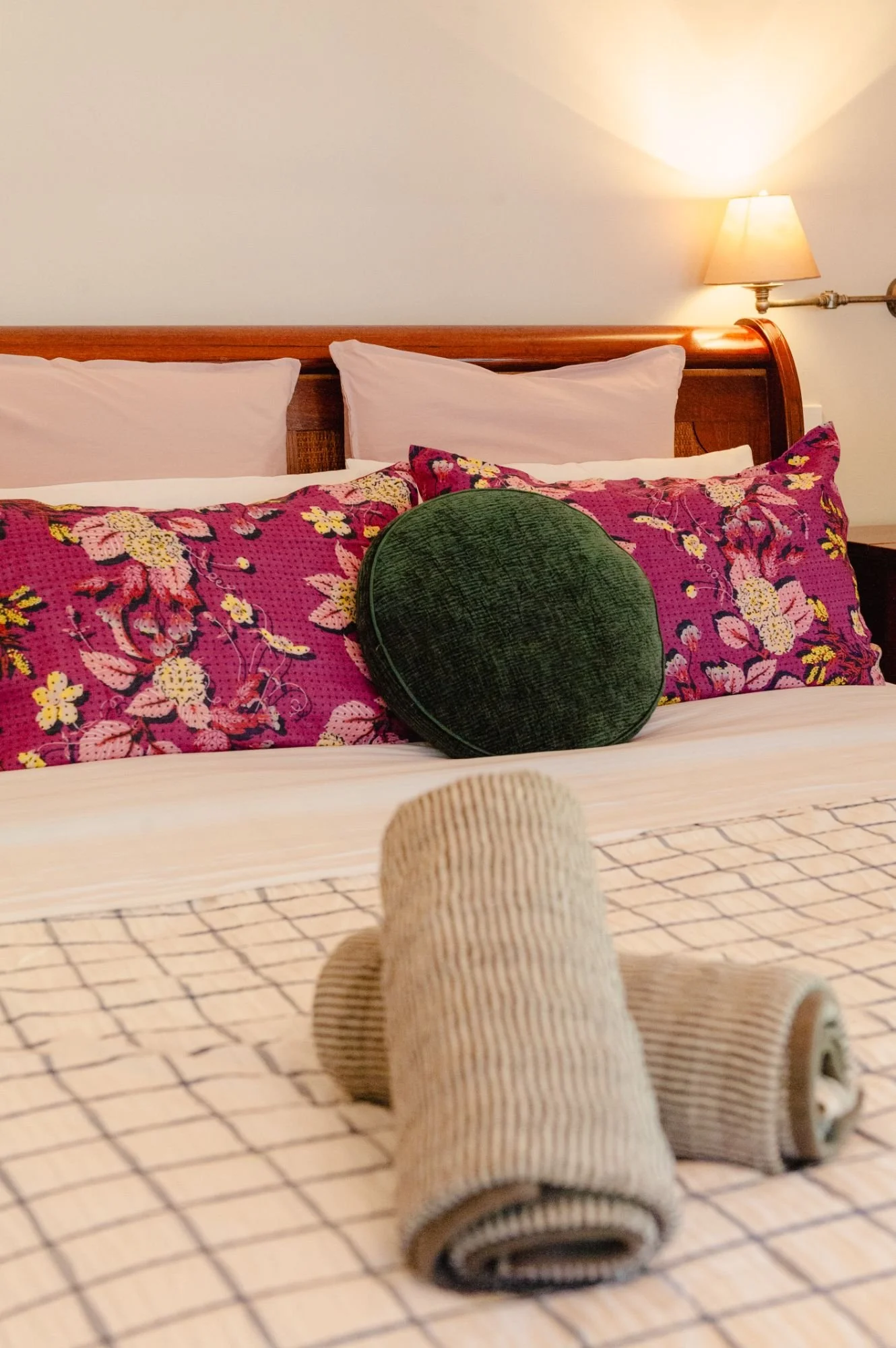 A cozy bedroom with a wooden headboard at Lanterns Retreat.
