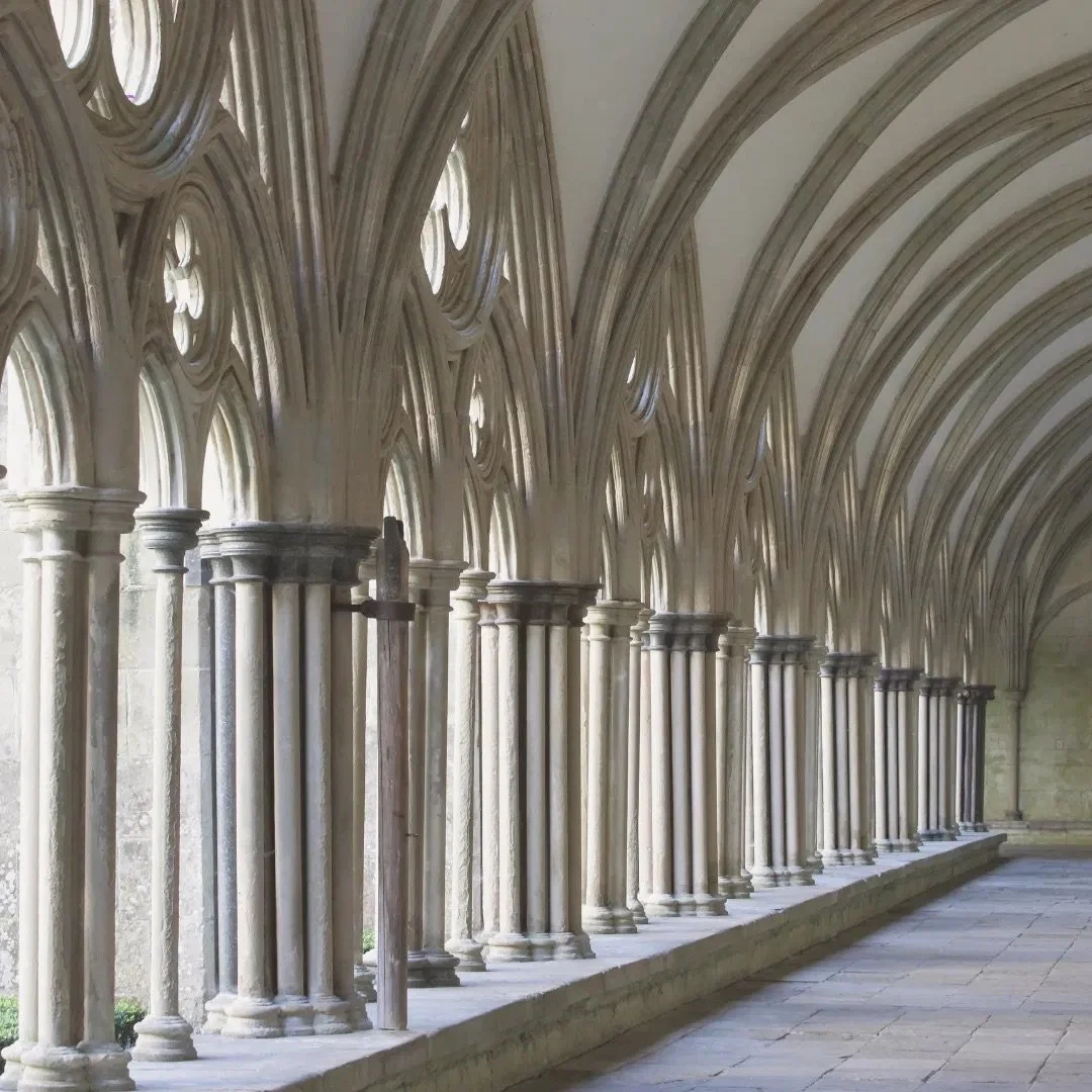 Gothic monastery cloister with stone arches and columns, reflecting Simon Goodrich's monastic background before moving his practice to Oxford