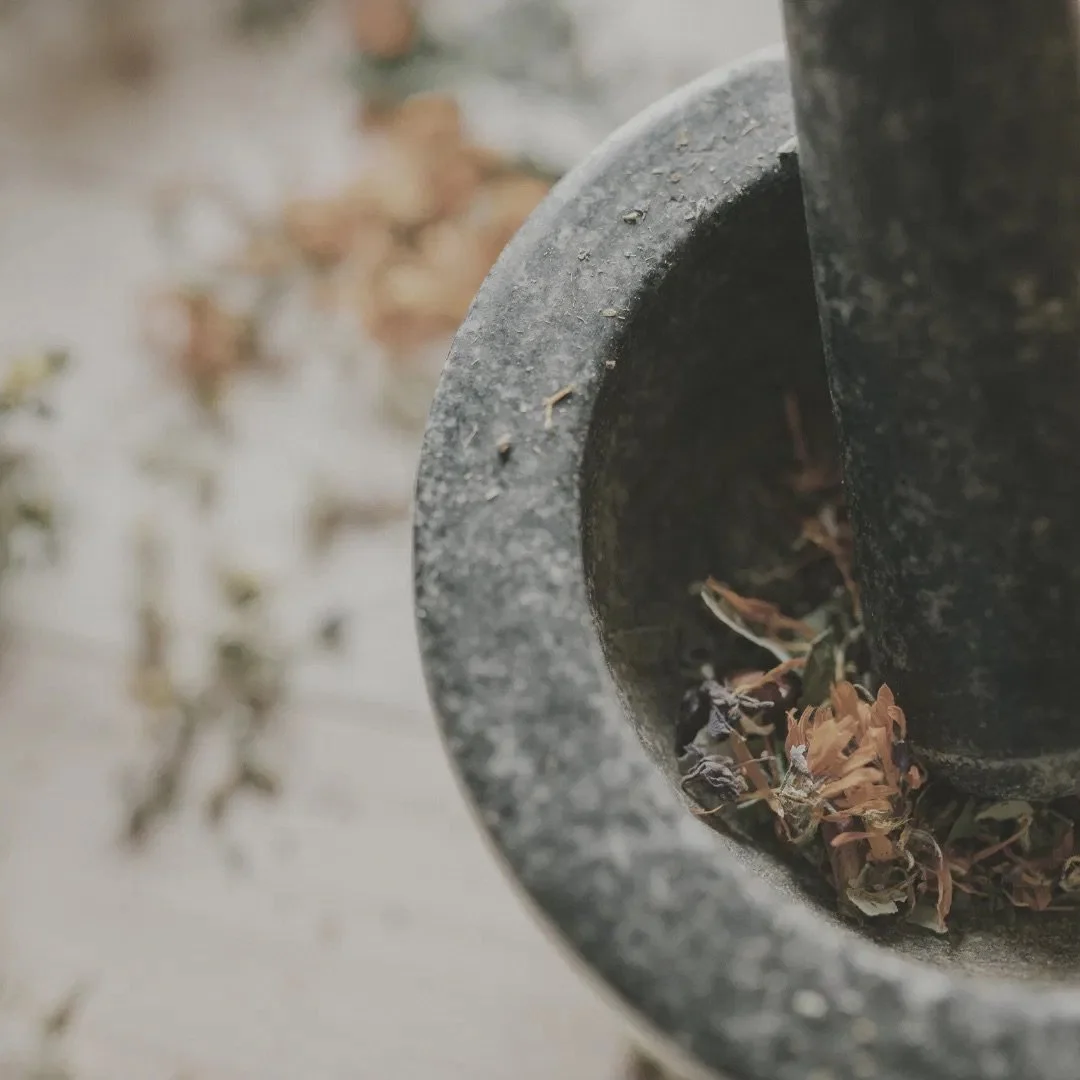 Stone mortar and pestle with dried herbs, symbolising Simon Goodrich's use of homeopathic remedies in his sessions