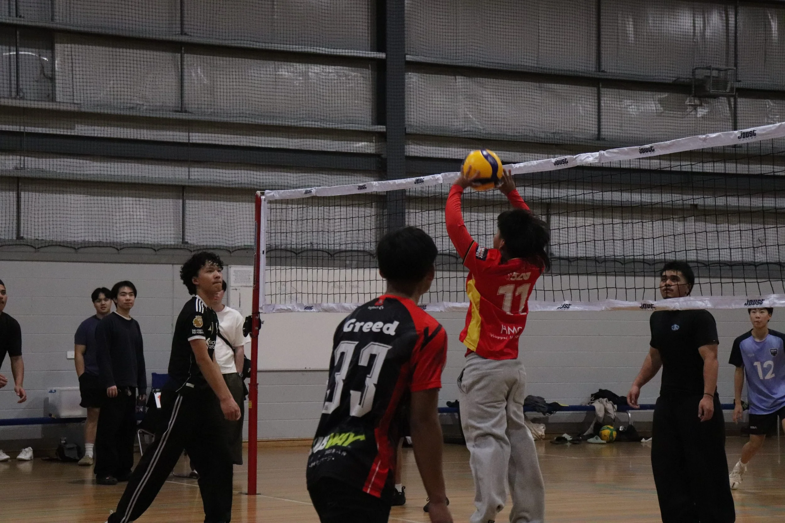 Indoor volleyball game with players and spectators watching