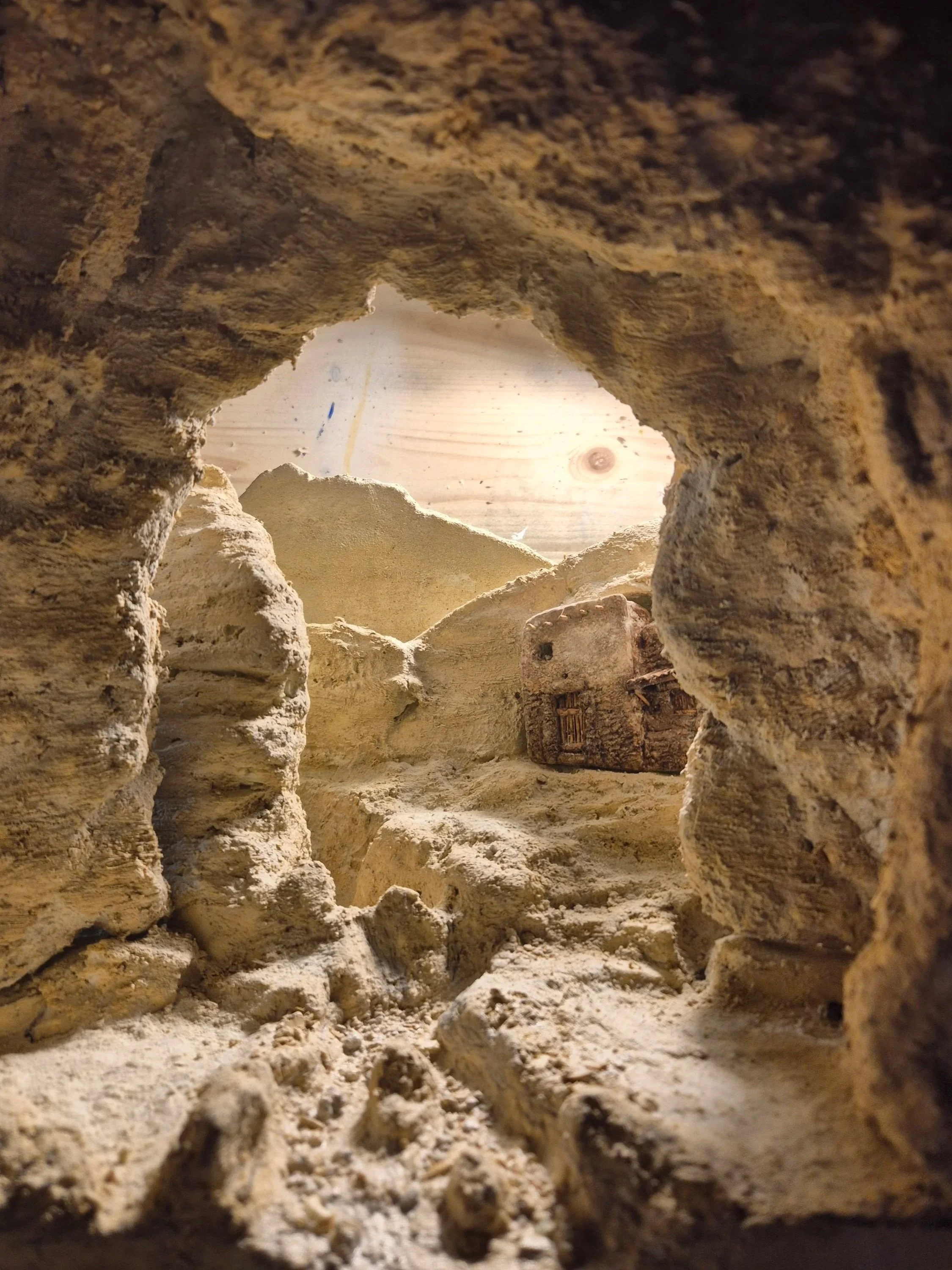Veduta di una cavità rocciosa con pareti di roccia giallastra e grotte o passaggi sotterranei.