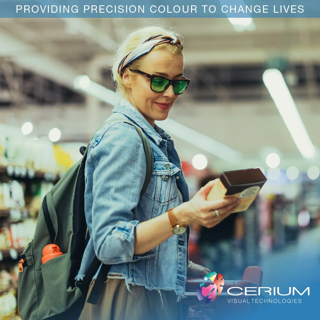 A woman with blonde hair, wearing sunglasses, a headband, and a denim jacket, shopping in a grocery store with a backpack and holding a product box.