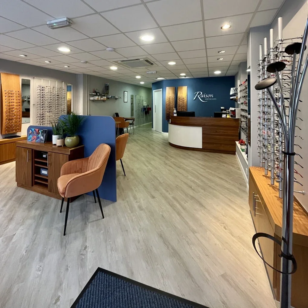 Interior of an Raison Optician's office with display shelves of eyeglasses and a reception desk.