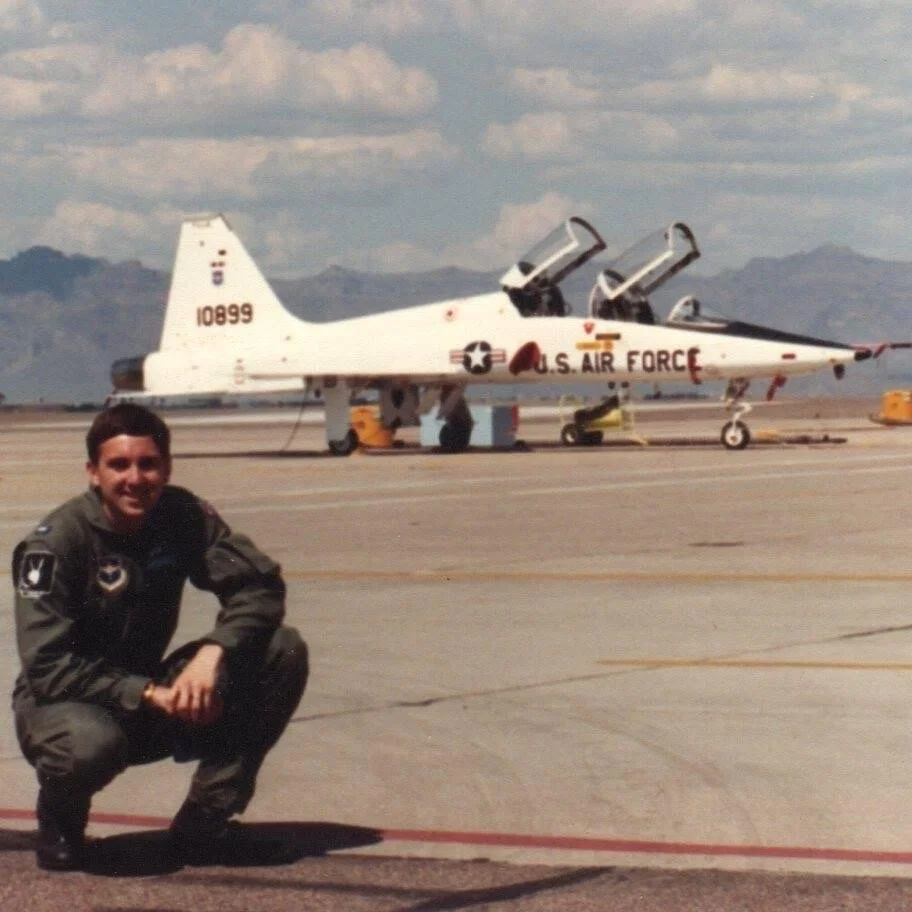 Robert Cummings beside a U.S. Air Force T-38 Talon trainer aircraft on an airfield.