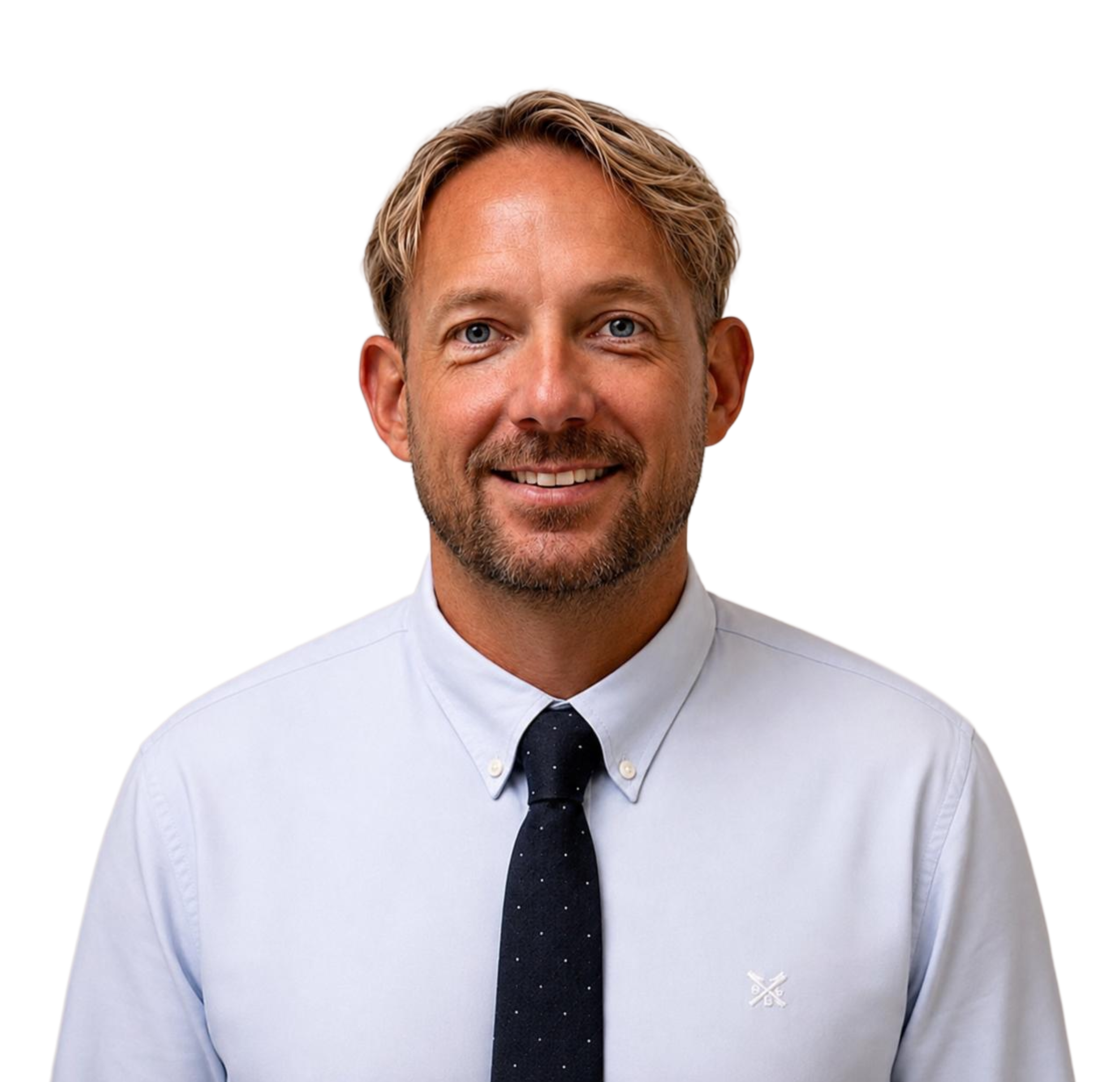 Close-up of a smiling man with blonde hair, wearing a white shirt, navy tie, and light blue sweater.