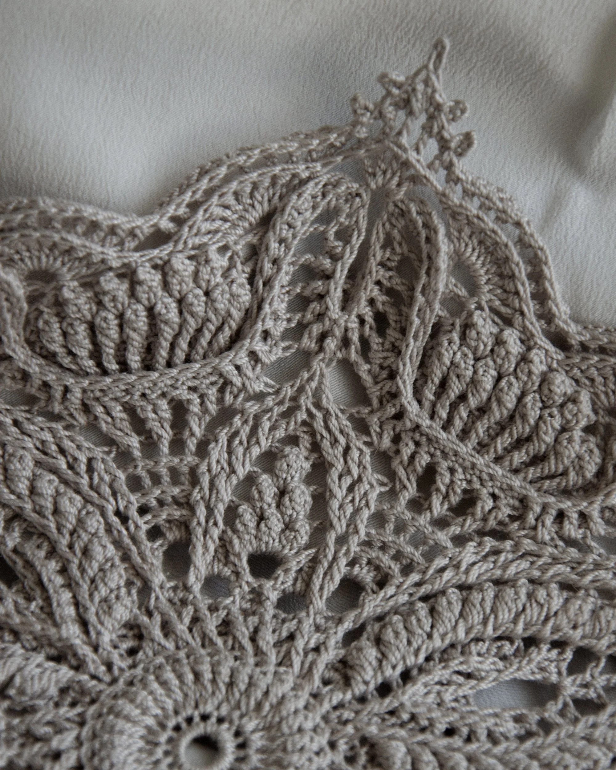 Close-up of the Inge crochet doily with sculptural lace details and a pointed motif