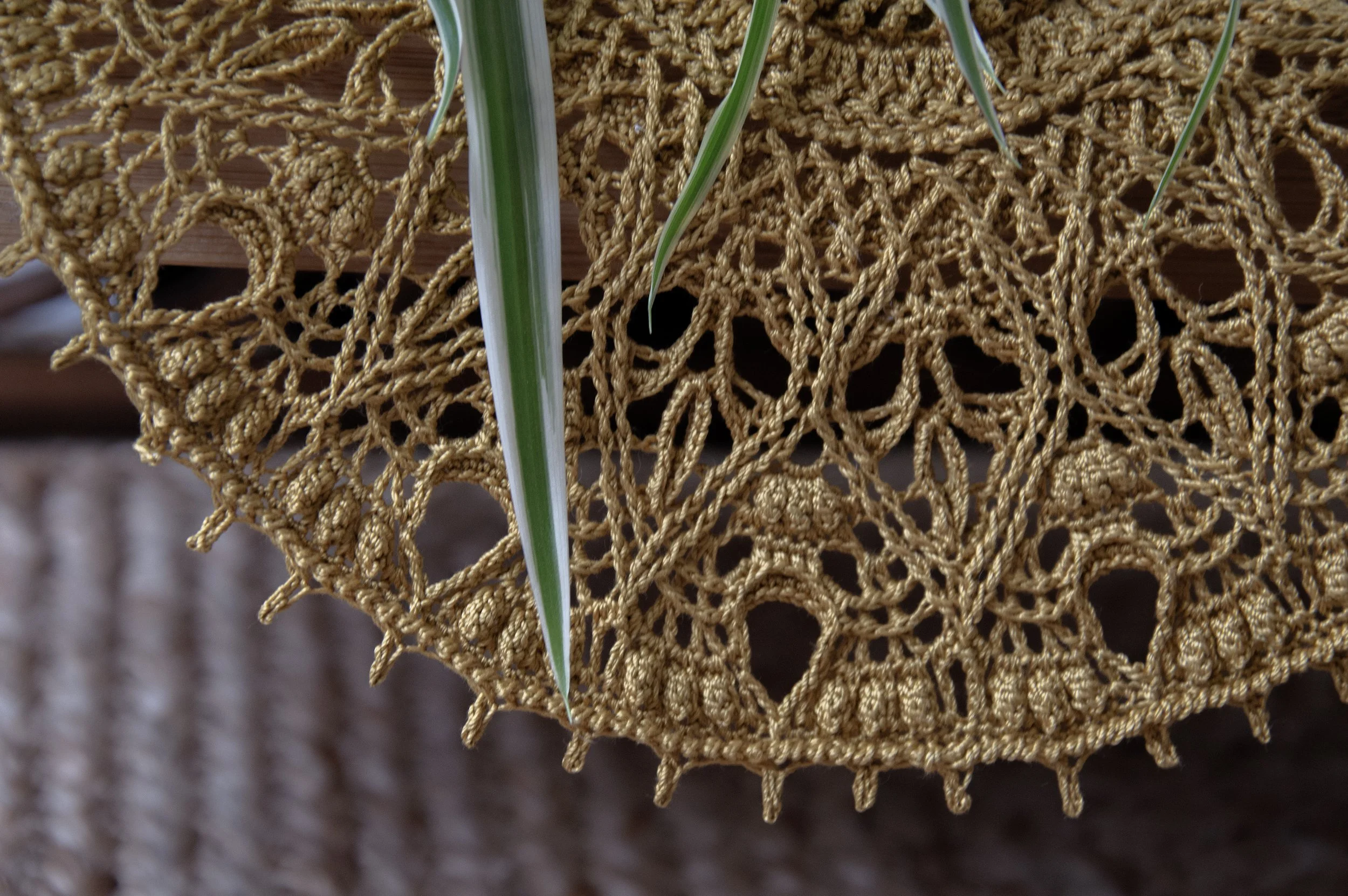 Close-up of the Meri thread crochet doily in warm brown, showing its delicate lace edging and sea-inspired motif