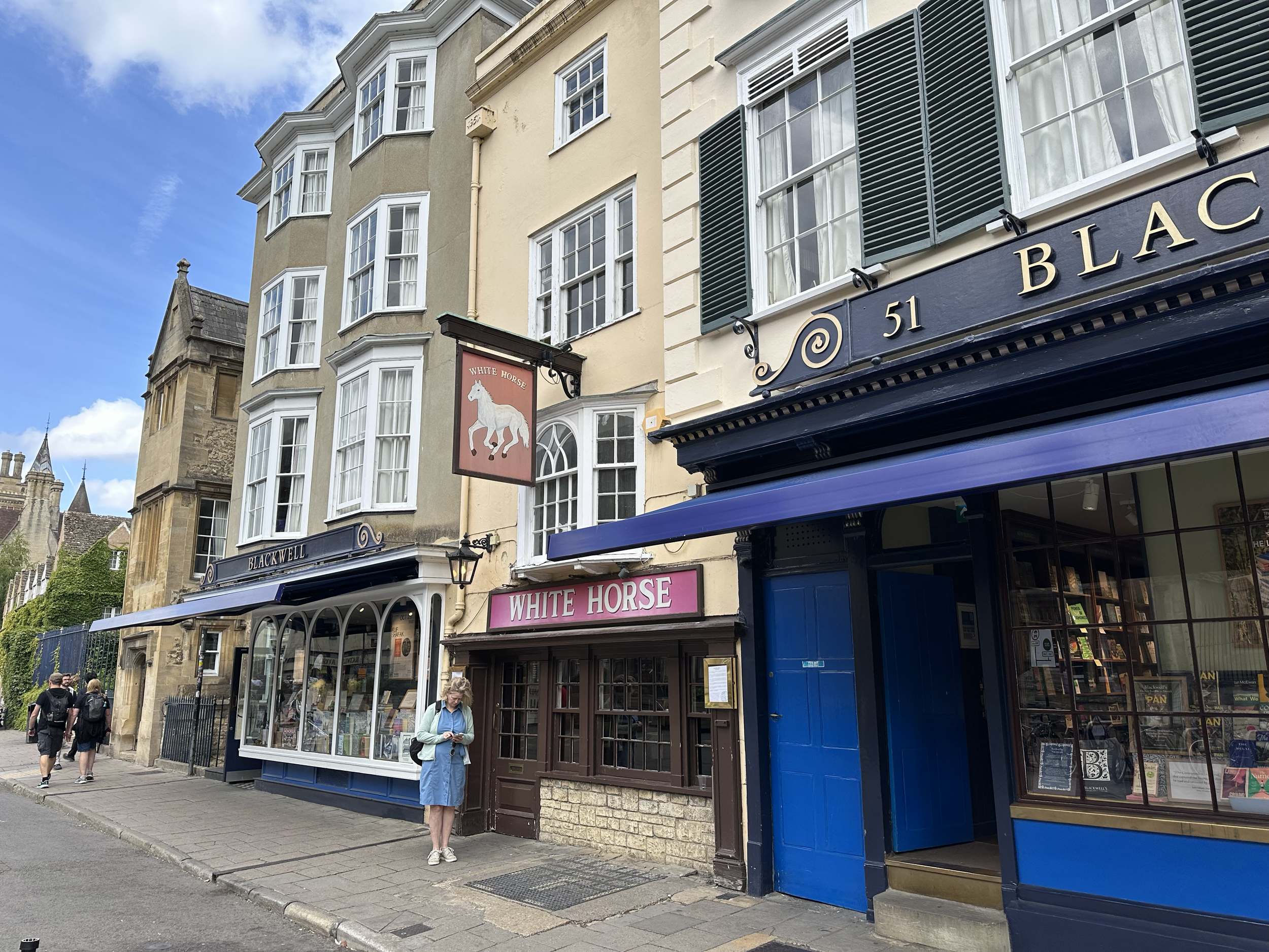 The White Horse resides between the two entrances to Blackwell's bookshop.  The White Horse is known to be the tiniest pub in Oxford. It dates back to the 16th century and was owned by Exeter College until 1980.