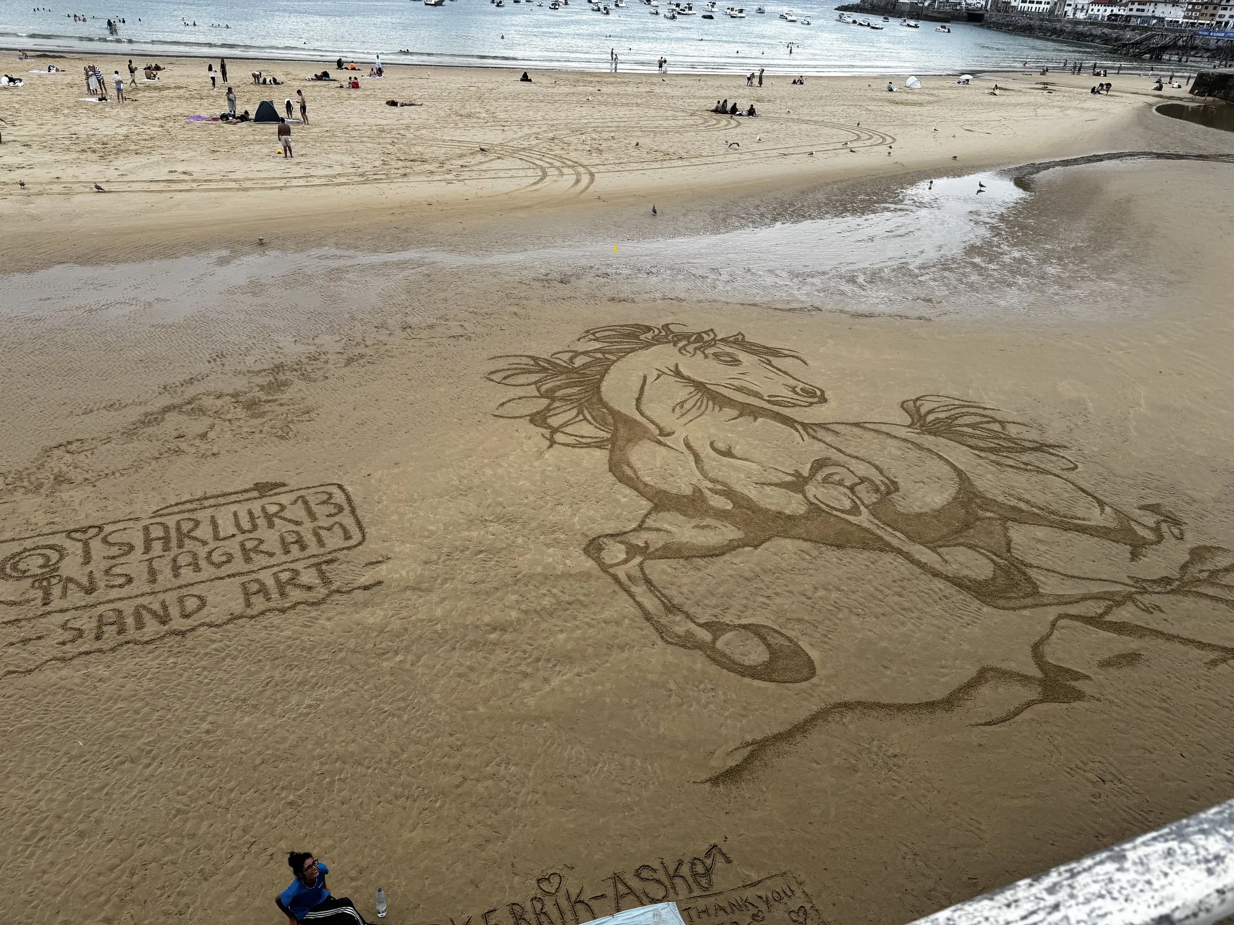 After eating, we made our way back to the beach.  We were really impresssed with the sand art and the artist's ability to draw such a large piece with correct proportions.  Amelia was so impressed that she dropped the artist a tip!

