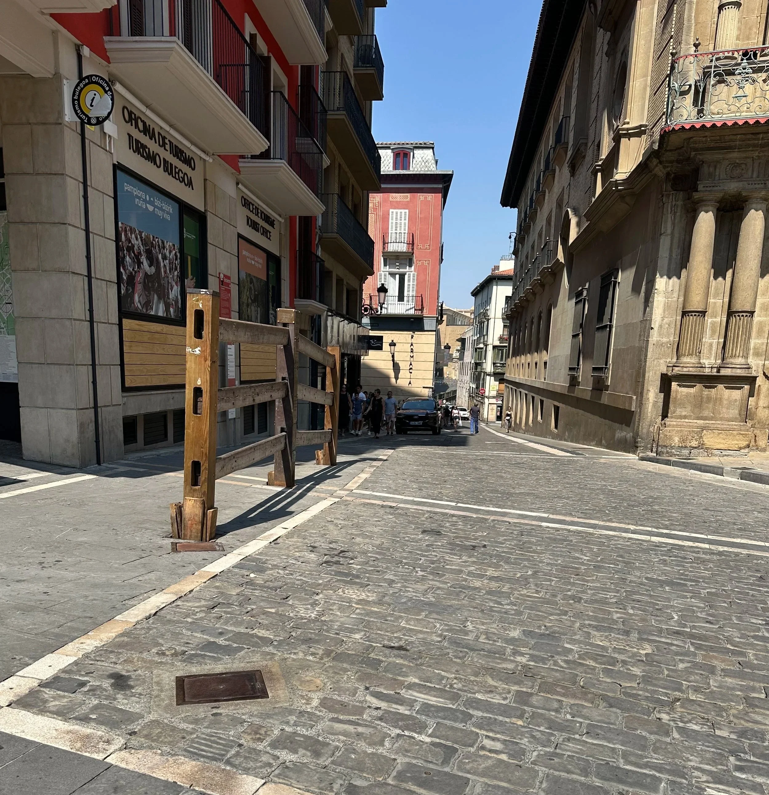 This is an example of how the fences are set up to separate the crowds from the bulls and runners.  The square metal plate on the street lifts up and the fence posts are installed.   Spectators are behind a double fence with at least a 5 foot space b