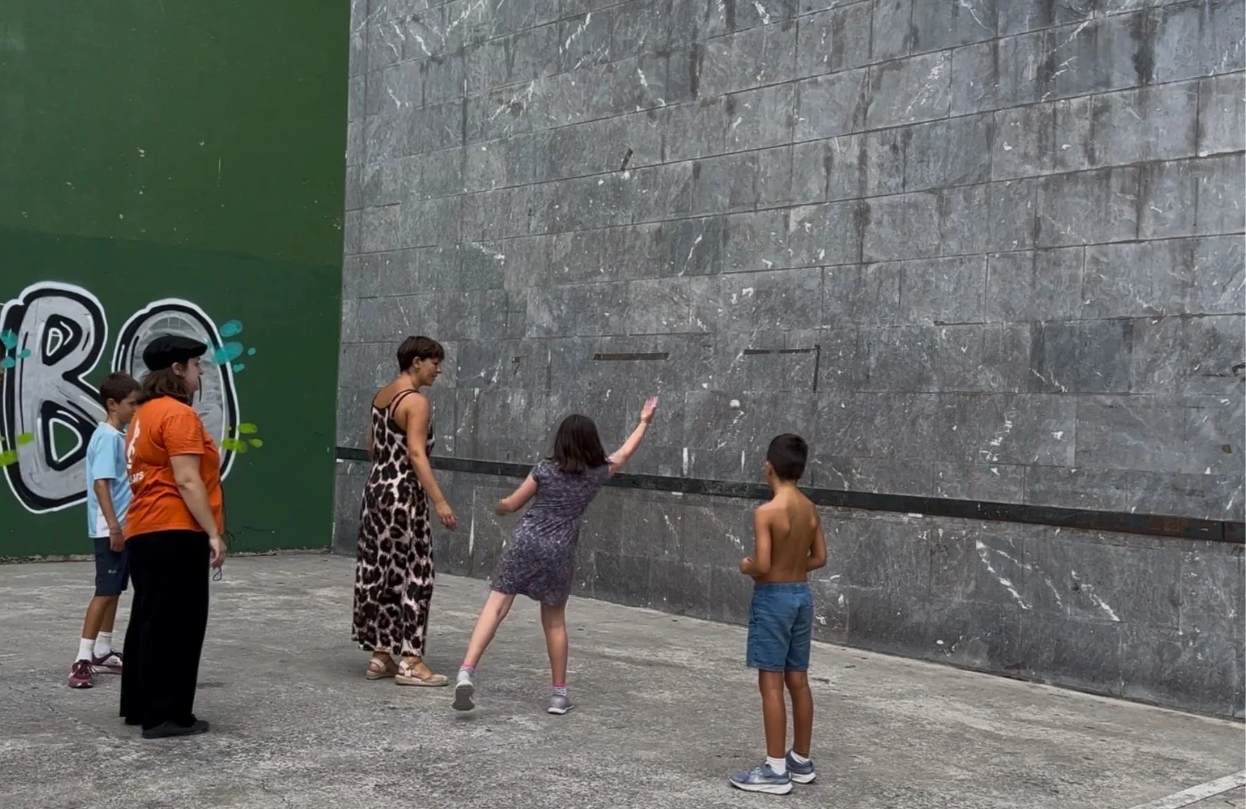 The game reminds me of raquetball, in that the ball is hit against a wall (above a line), back and forth between two people. Sometimes a paddle is used, but usually your hand is the paddle.