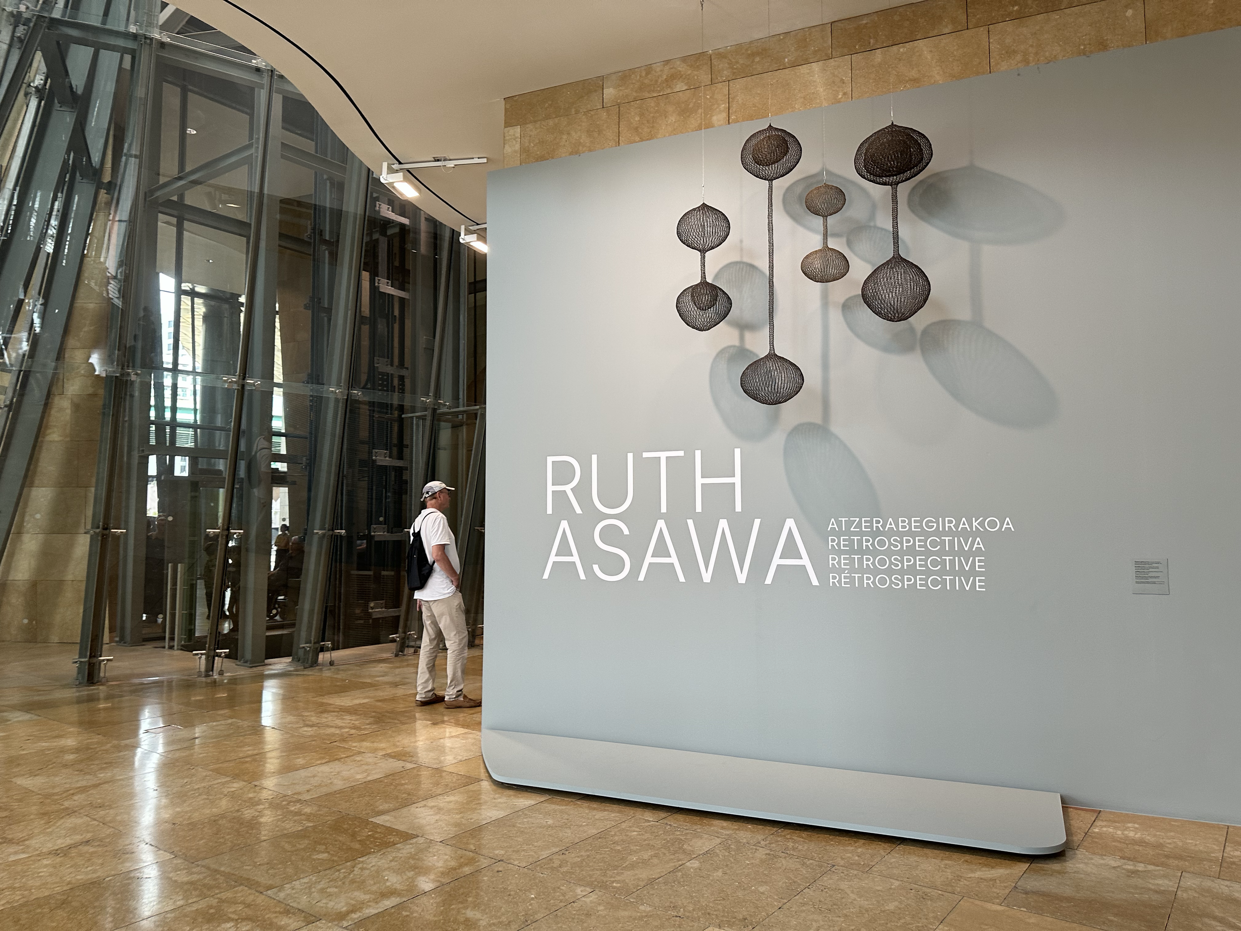 Ruth Asawa works in metal wire, creating forms within forms by weaving a continuous wire into a looped wire structure.