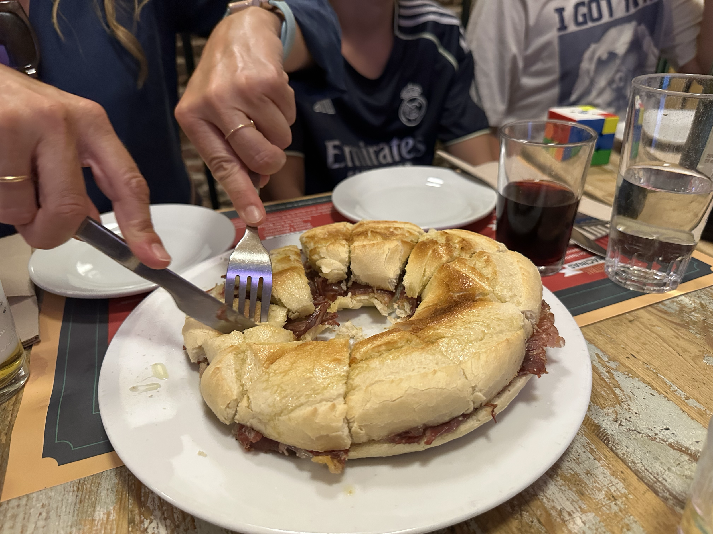 Our first restaurant "Alemendro 13" is known for their Rosca Jamón Ibérico con Brie.  It's like a really large bagel with thinly sliced Ibérico ham and brie cheese that you cut up into sections to share.  (In the picture of all of us you can see anot