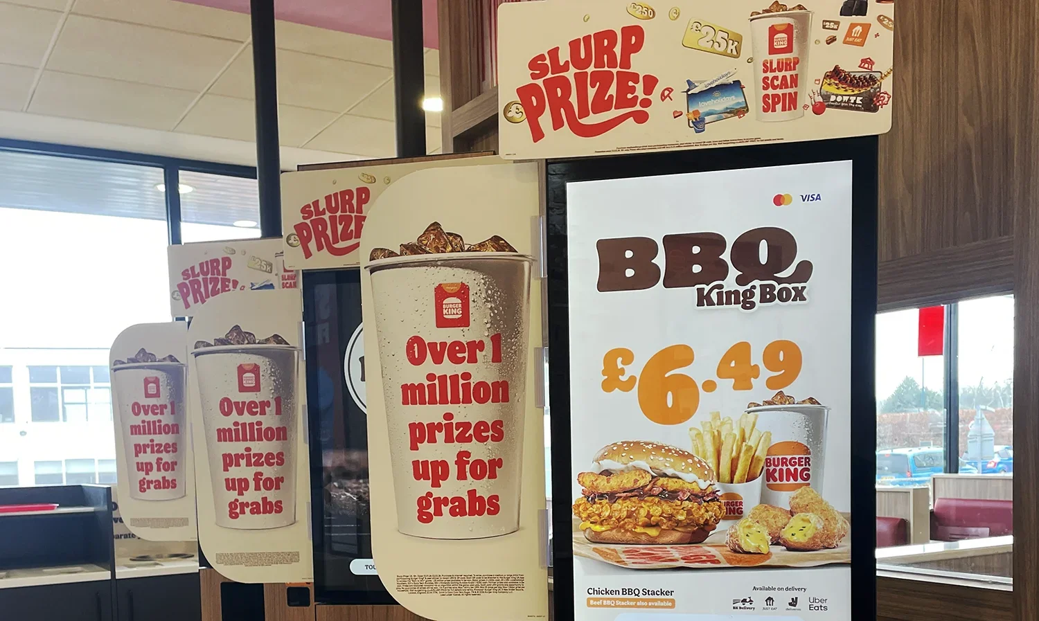 Giveaway promotion ads around a Burger King self order POS machine