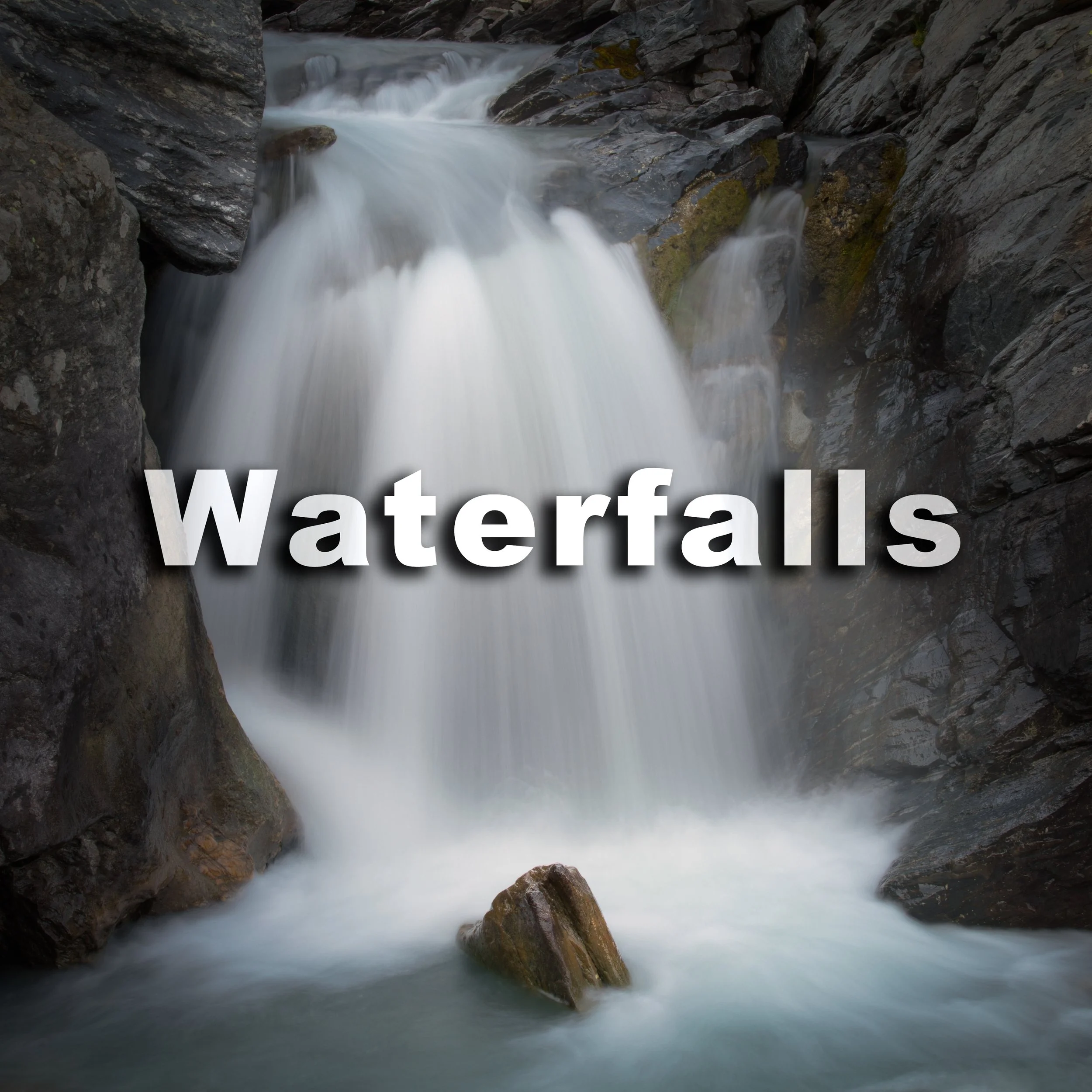 A waterfall flowing between rocks in a canyon.