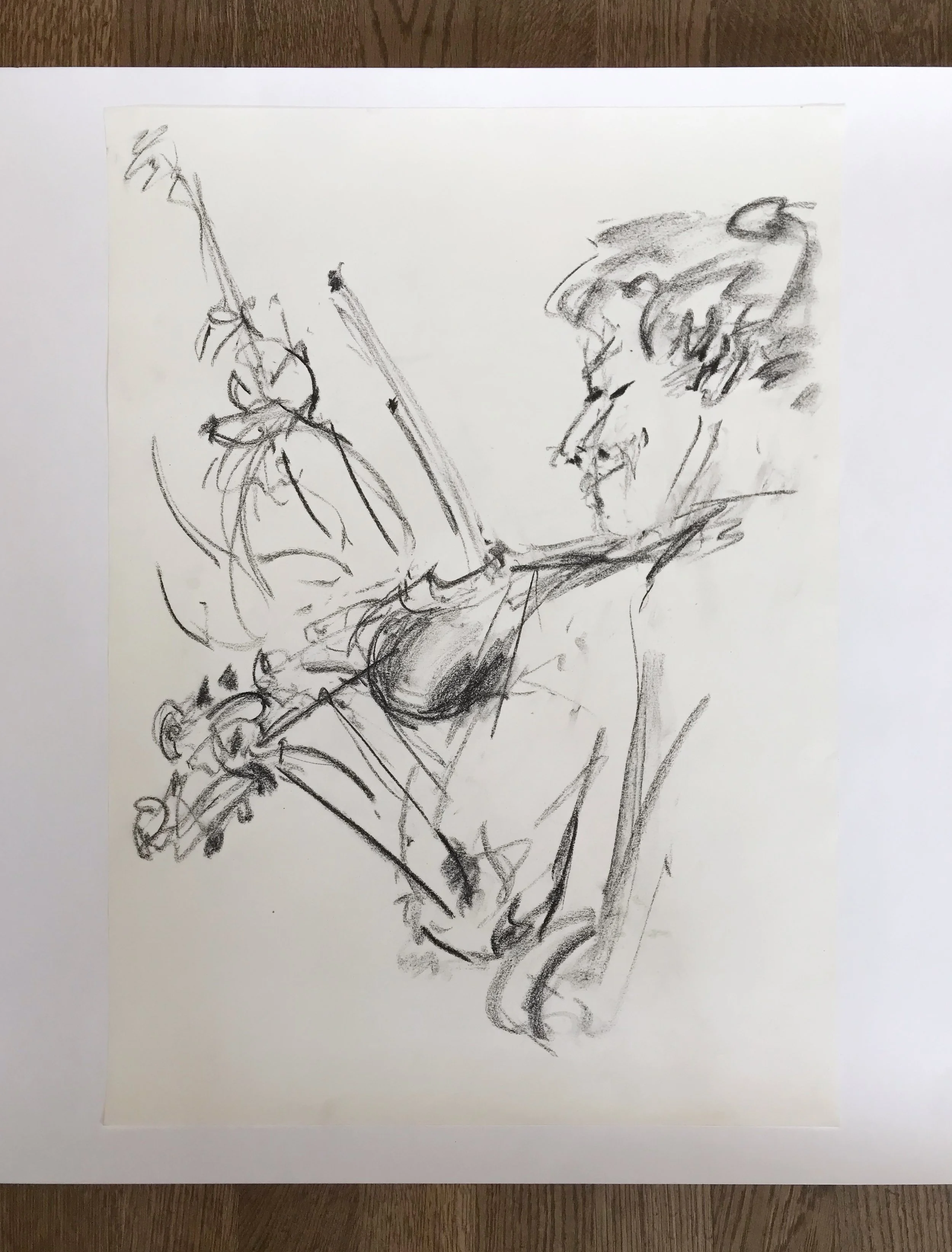 A sketch of a person, drawn with loose black lines on white paper, showing the person's profile with a hat or head covering, holding an object that appears to be a stick or pole.