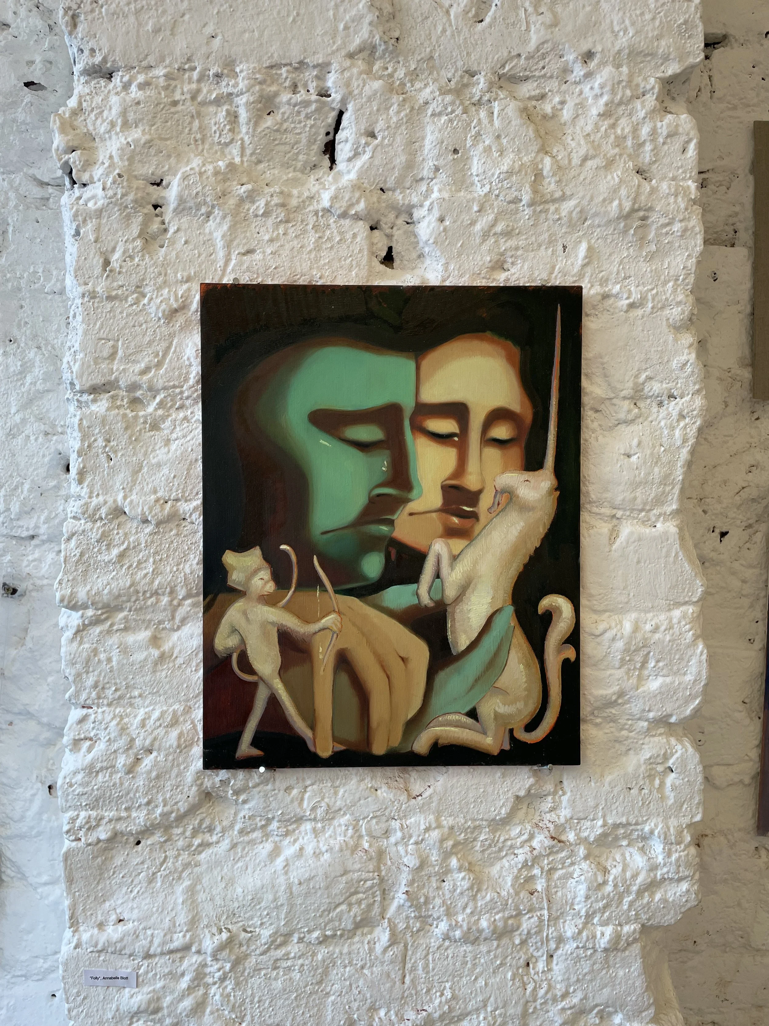 Painting titled "Folly" by Annabelle Blott featuring stylized portraits of two people with closed eyes, surrounded by symbolic animal motifs.