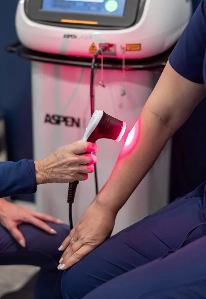 Medical procedure where a healthcare professional is using a laser device on a patient's forearm in a clinical setting at Accent on Health Chiropractic best chiropractor near me